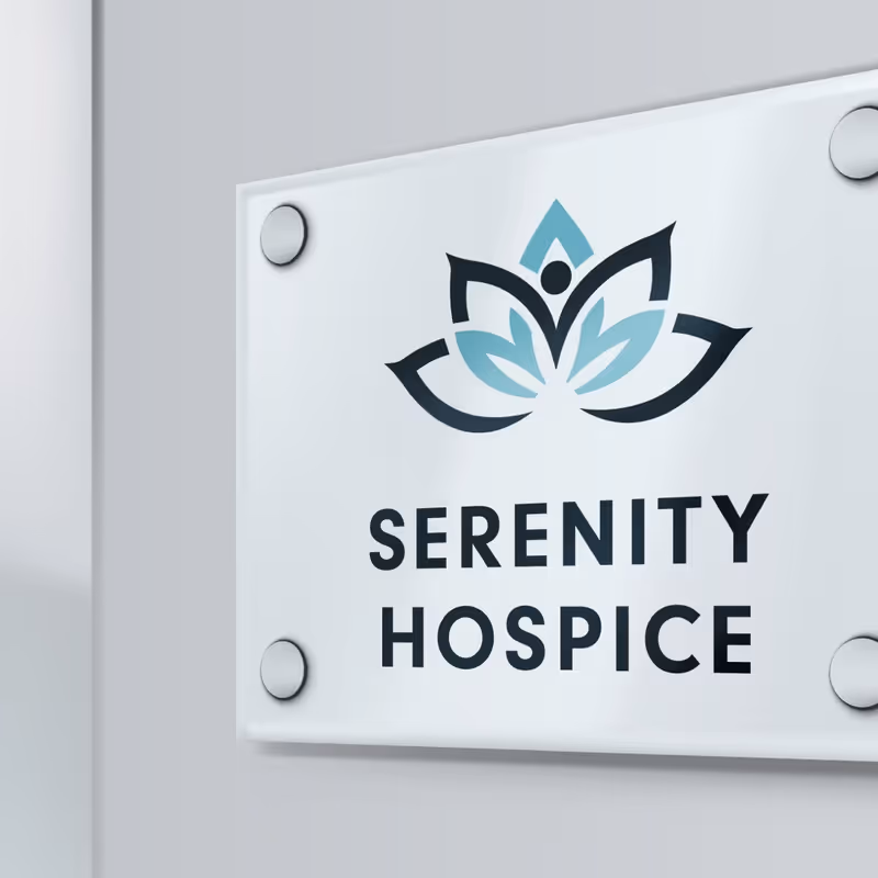 A Serenity Hospice sign with a lotus logo mounted on a light gray wall.