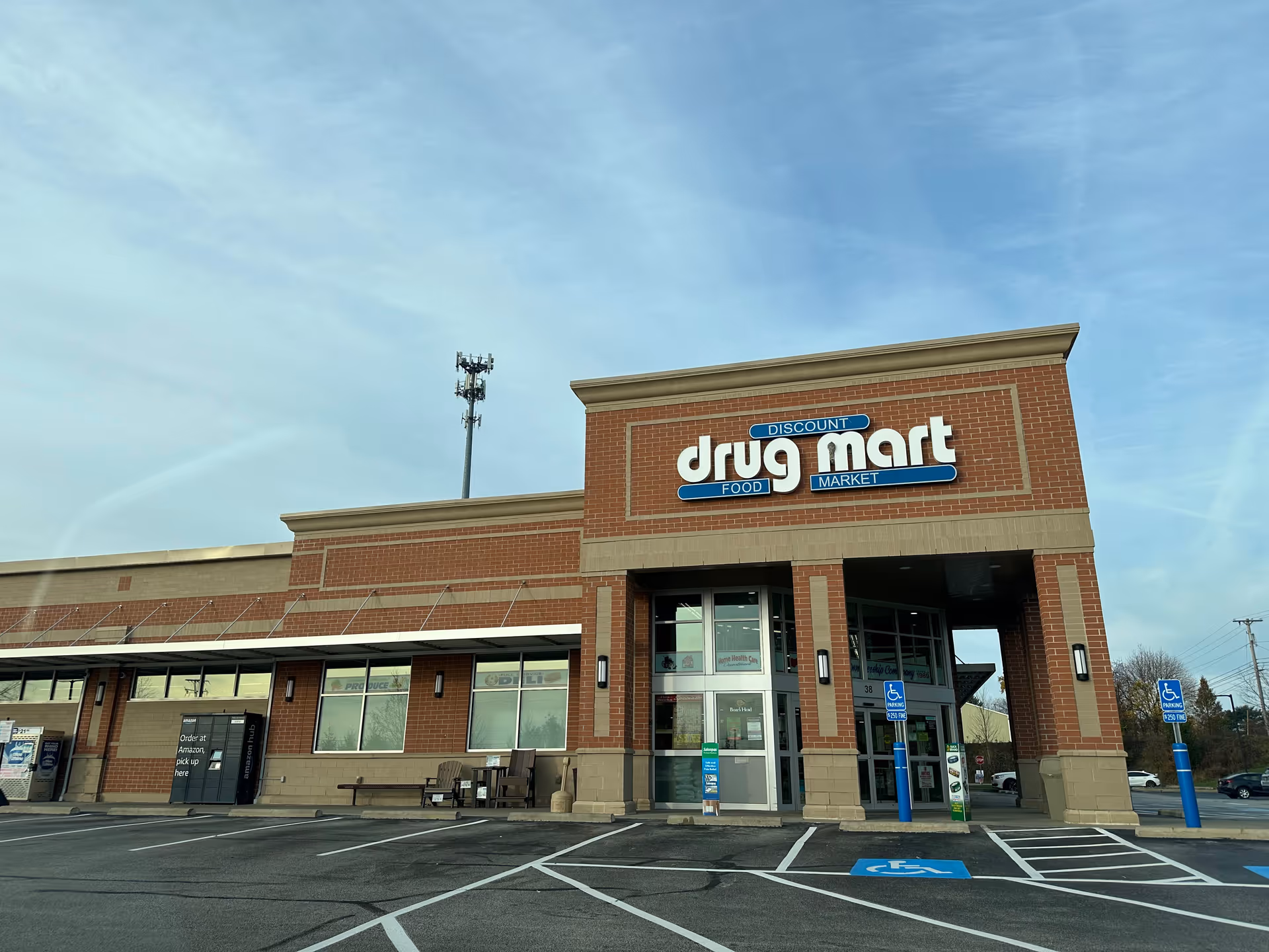 Brick storefront of Discount Drug Mart with parking spaces and blue handicap signs.