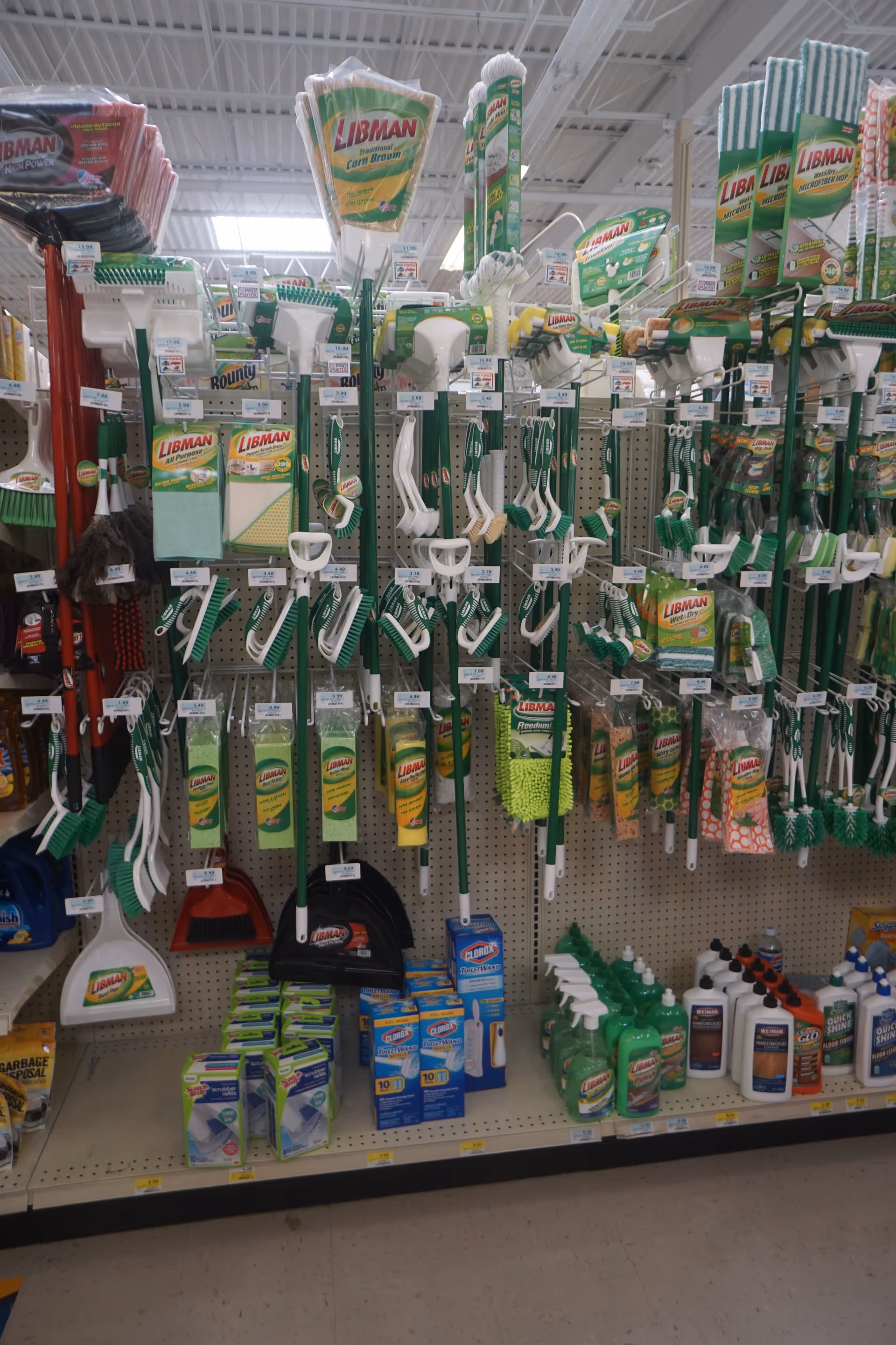 This indoor store aisle shows green-and-white Libman cleaning tools and supplies.