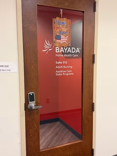 Wooden door with BAYADA Home Health Care signage in an interior hallway.
