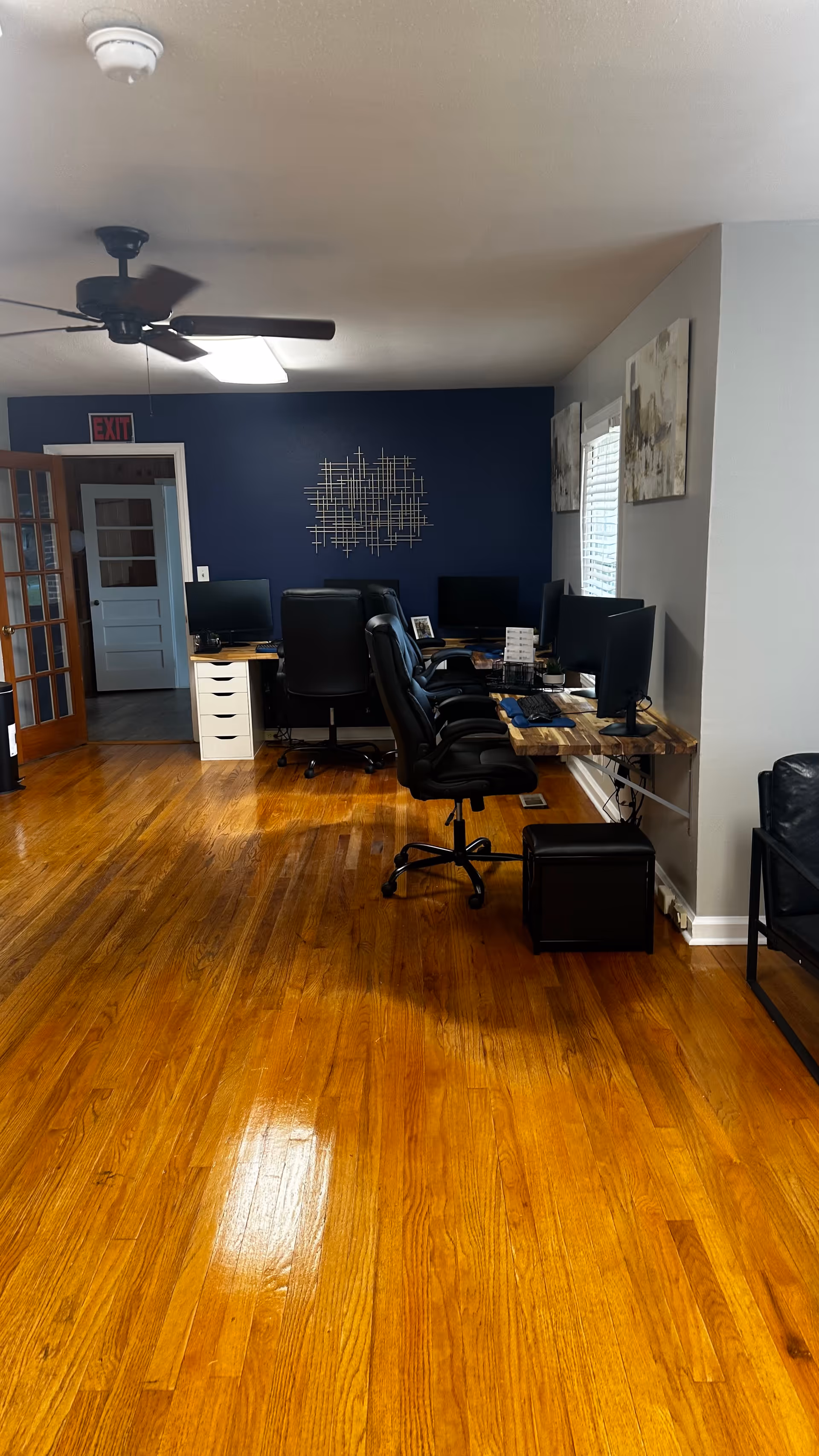 Office workspace with several computer desks against a blue wall in a senior facility.
