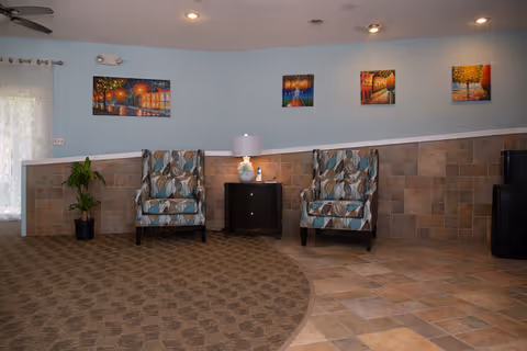 Pastel blue lounge area with two patterned armchairs and a small side table.