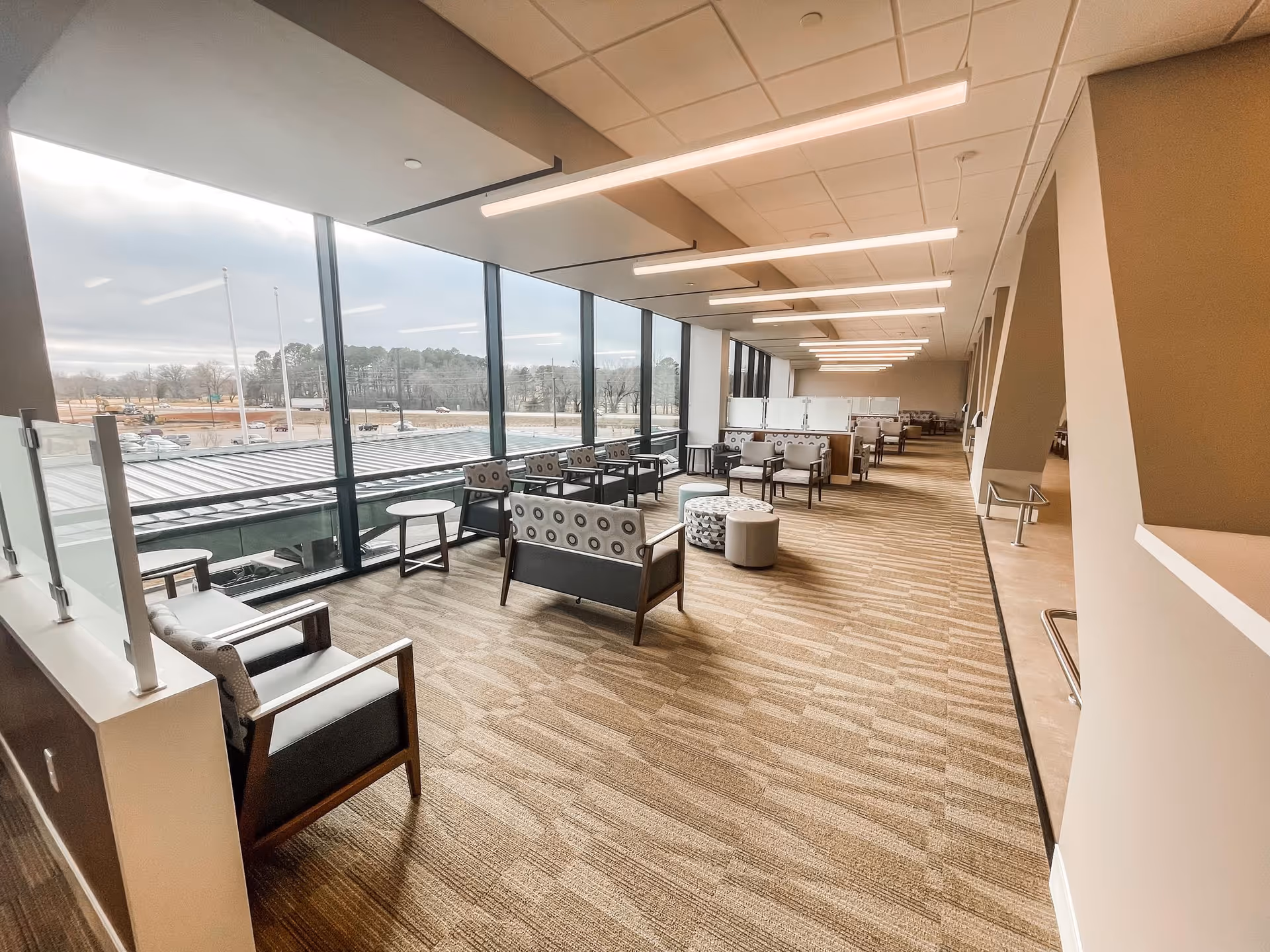 Spacious modern lounge with multiple seating areas along large glass windows.
