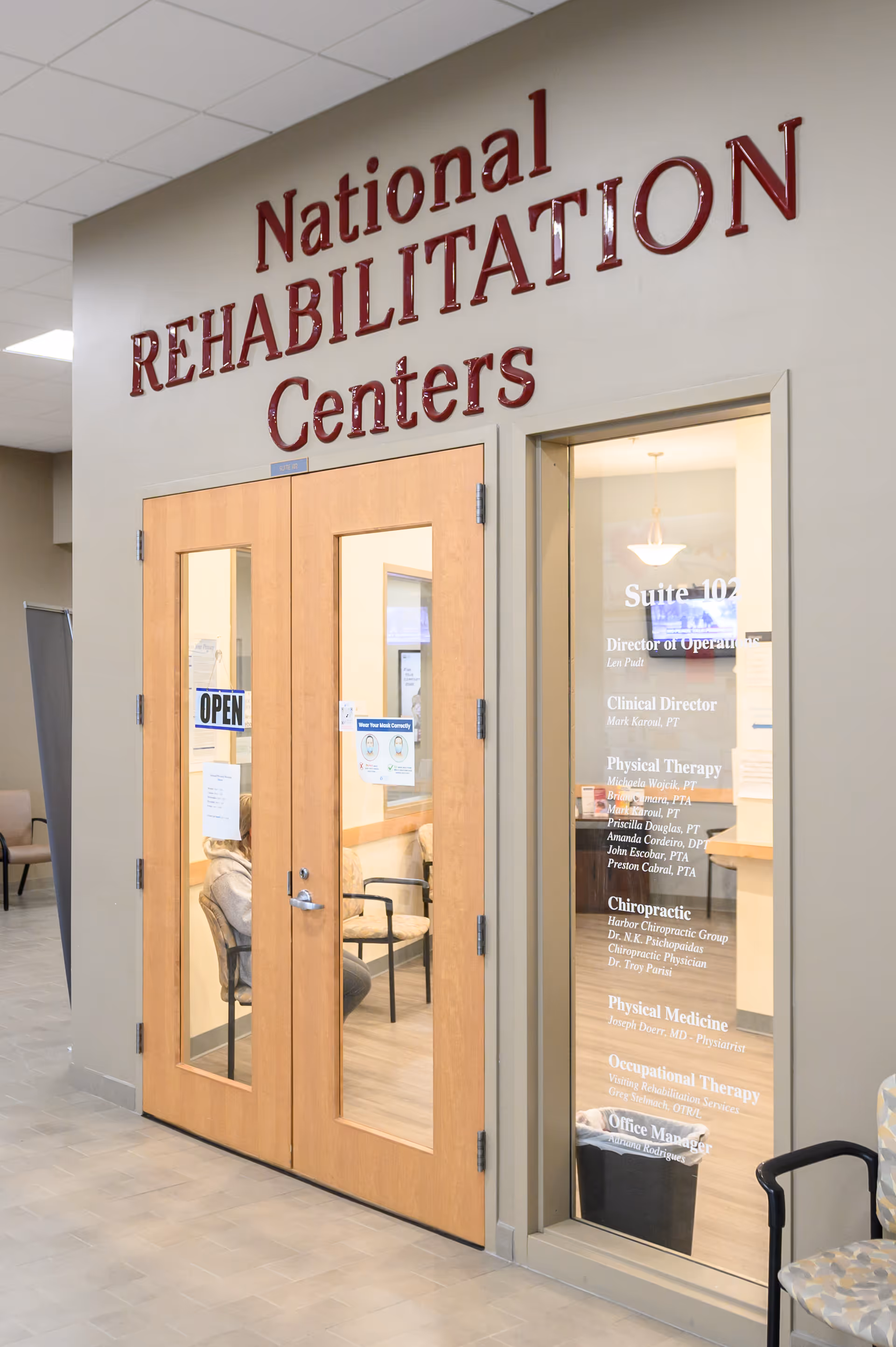 Interior hallway with wooden double doors and National Rehabilitation Centers signage.