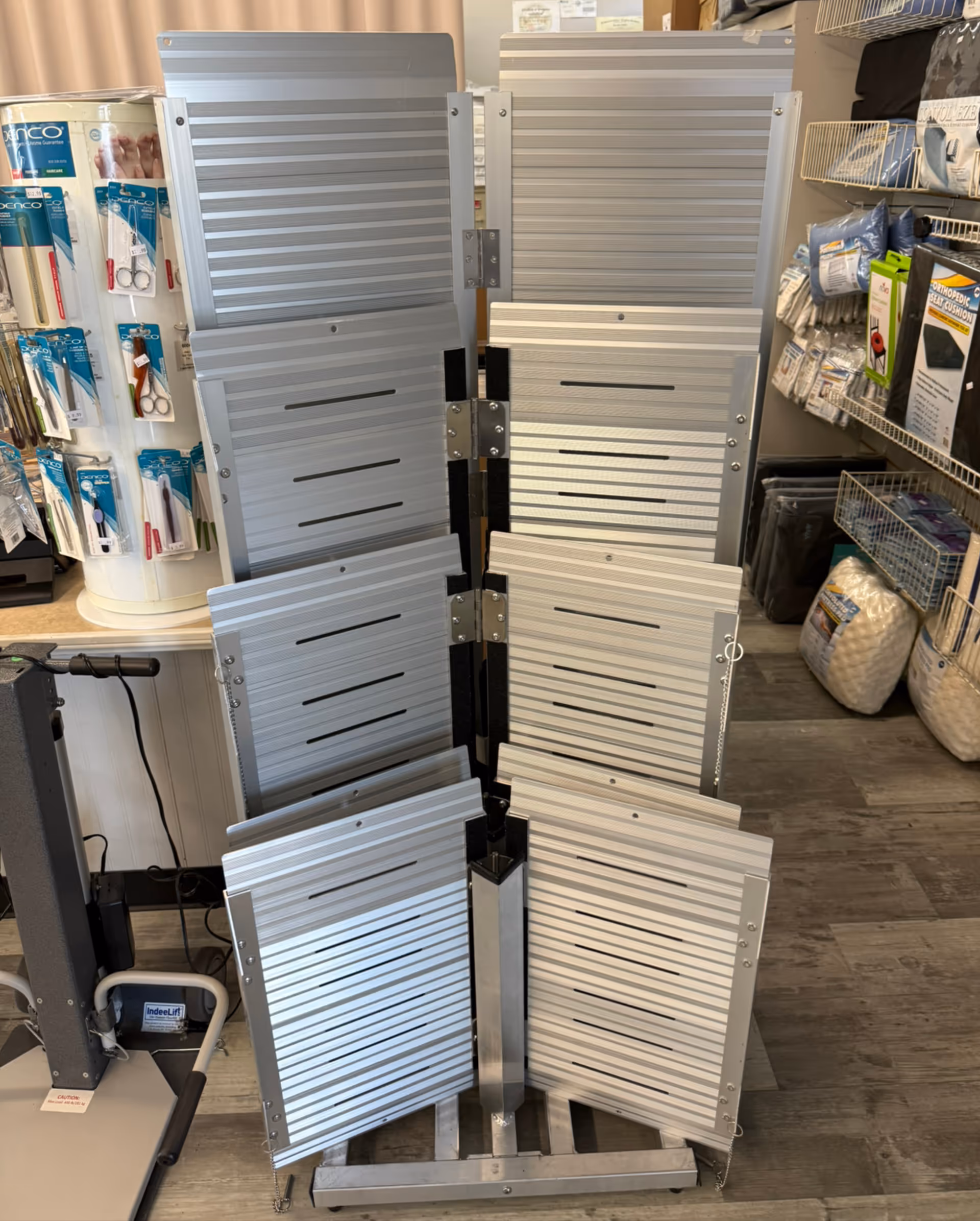 Vertical display of metal slatted panels stacked on a stand in a medical supply store.