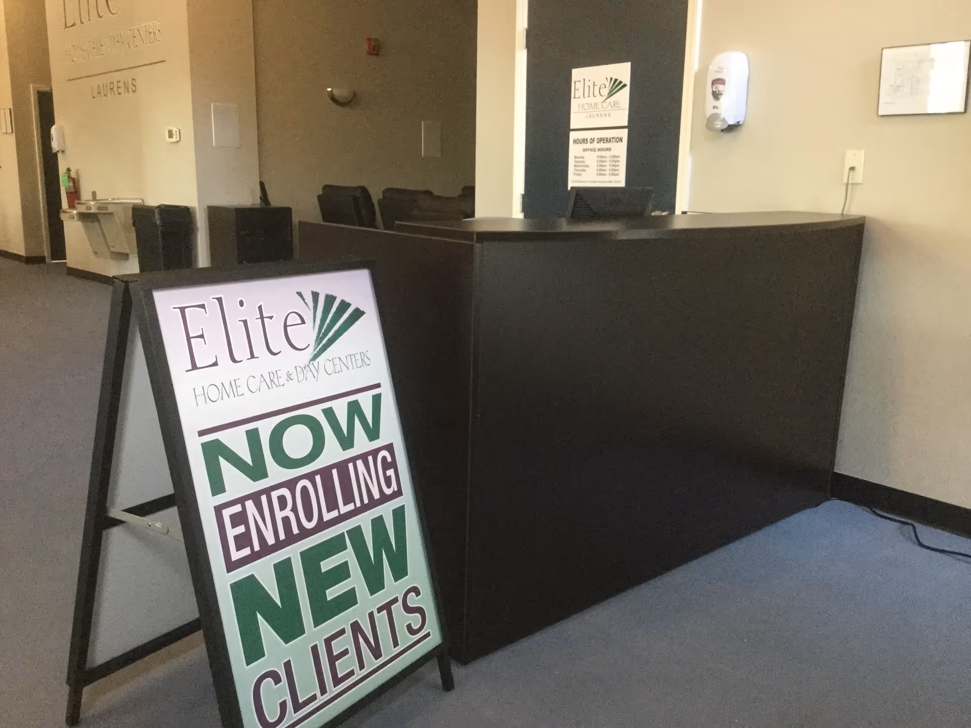 Interior reception area of a senior care facility with an enrollment sign.