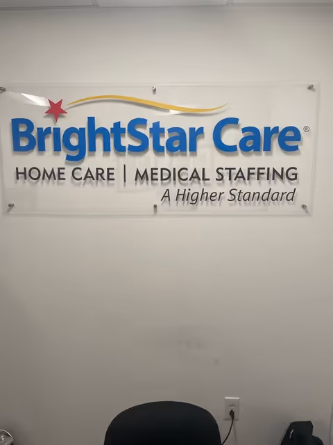 Interior wall displays BrightStar Care sign with home care messaging and a chair in foreground.