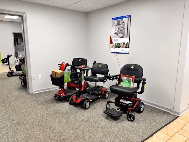 Indoor hallway featuring parked mobility scooters and equipment.
