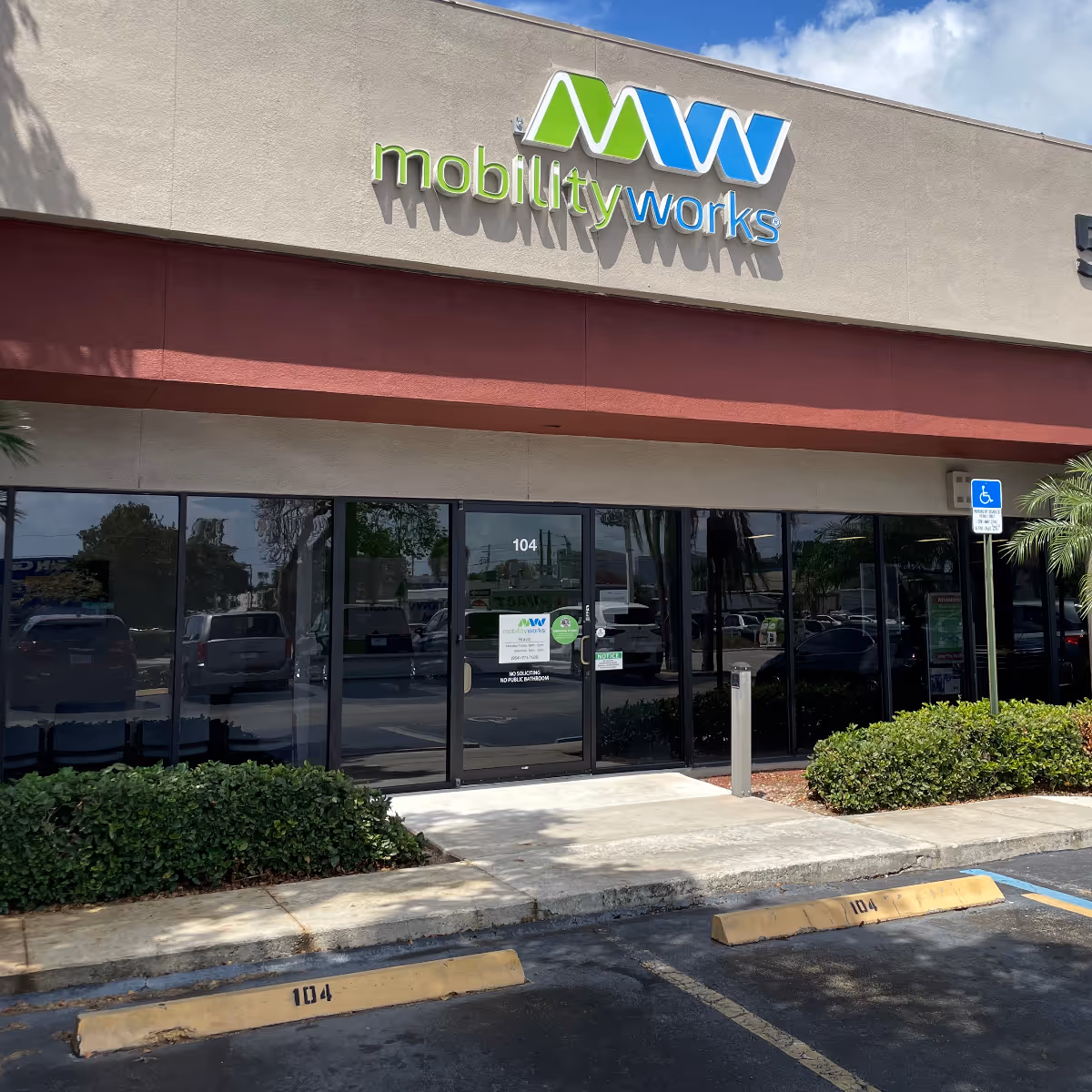 Exterior view of MobilityWorks storefront with large glass doors and handicap parking.