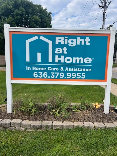 A Right at Home outdoor sign in a grassy yard advertising In Home Care & Assistance
