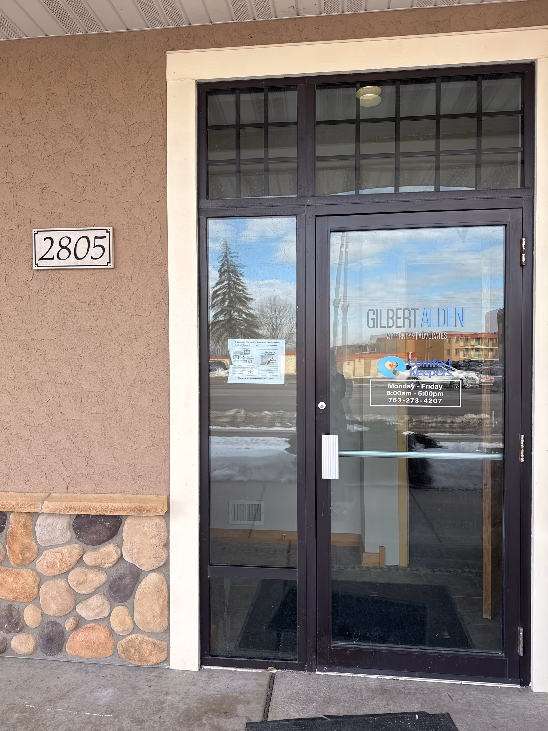 Exterior entrance with glass door, stone facade, and the address 2805.
