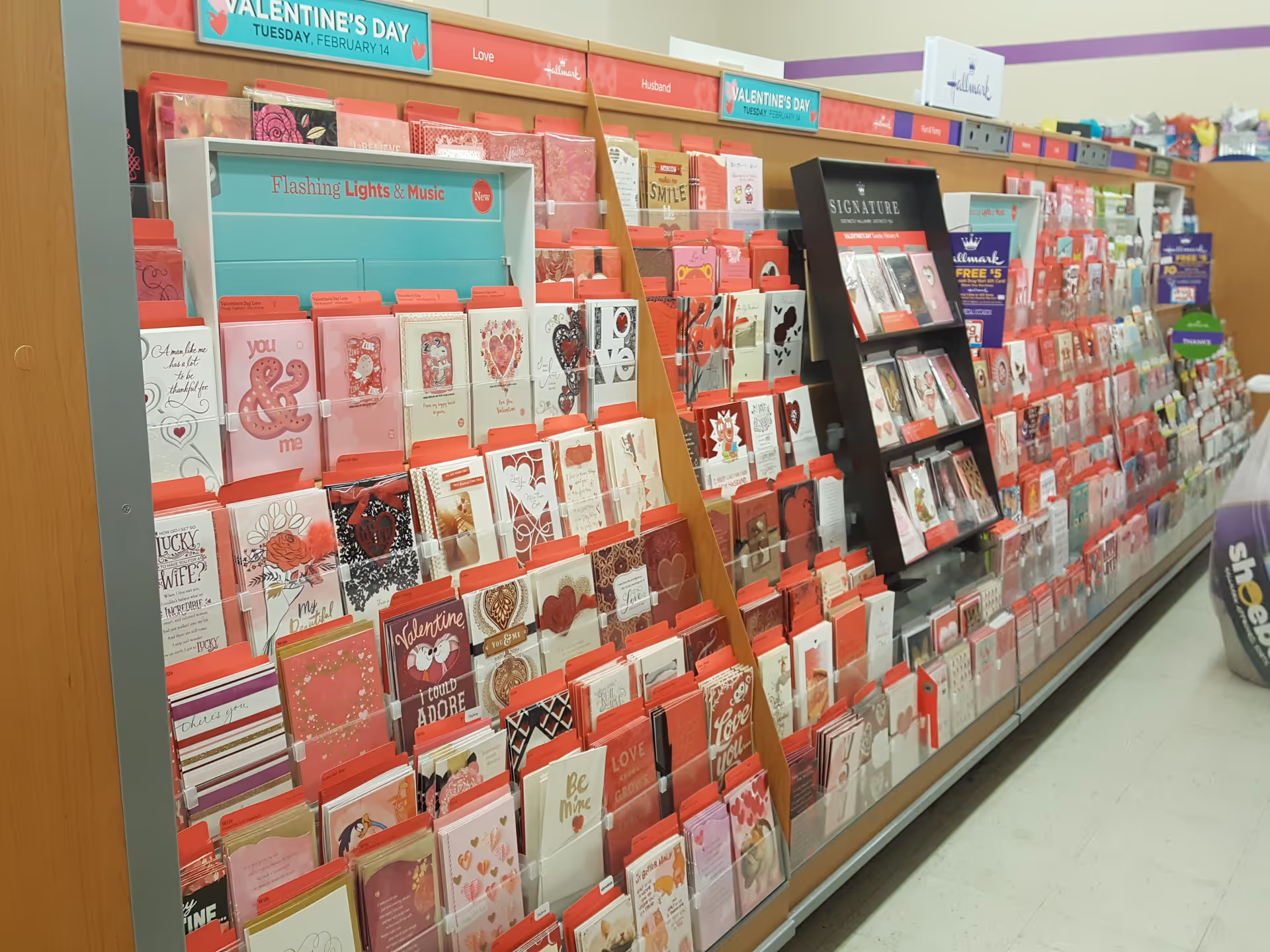 A Discount Drug Mart aisle of greeting cards and Valentines displayed on shelves.