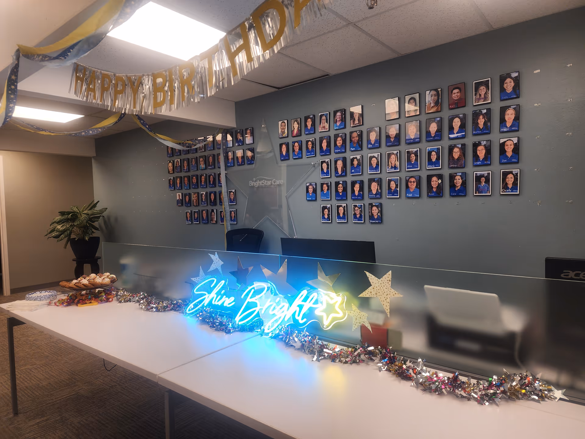 BrightStar Care reception area with birthday banner, snacks, and wall of staff photos.