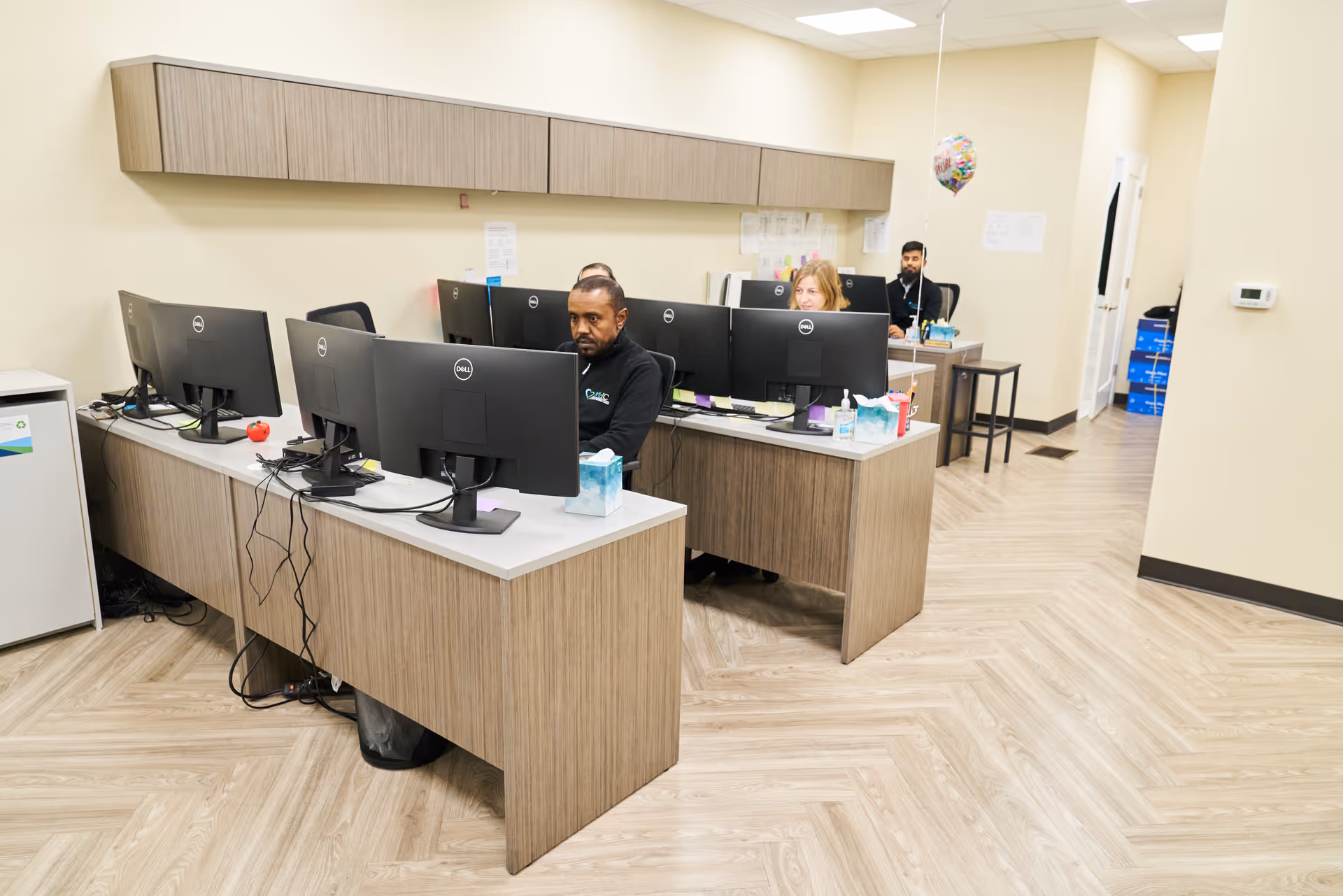Interior computer station area with staff working at desks inside a senior facility.