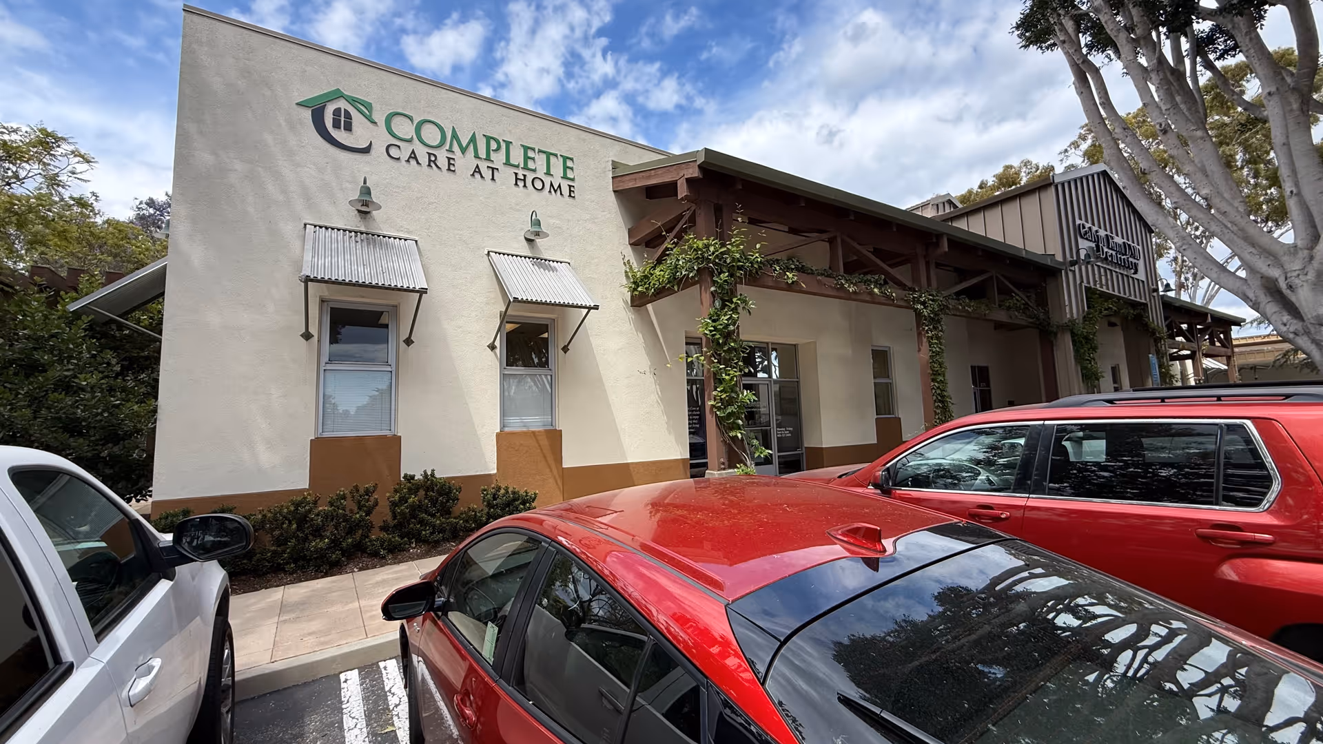 Front exterior of Complete Care at Home building with parked cars.
