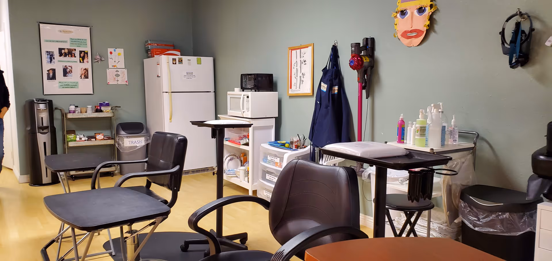 Interior treatment room with multiple chairs, a refrigerator, and medical supplies.