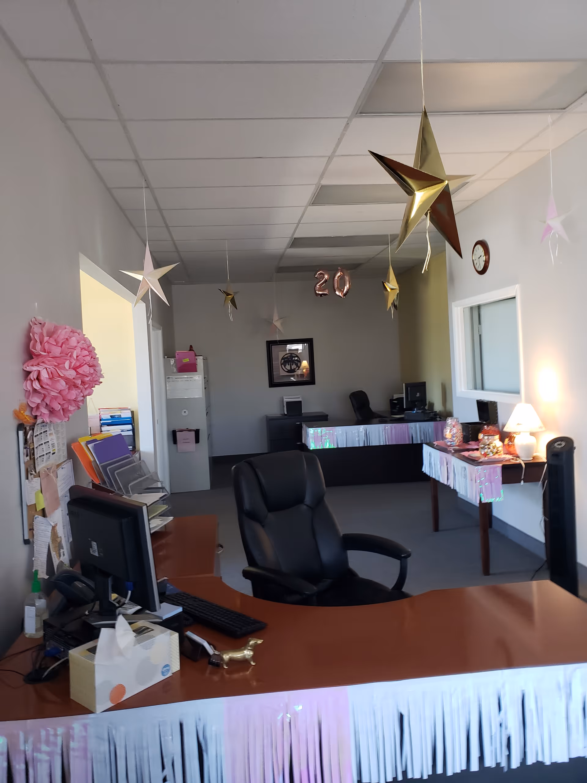 Reception desk in a decorated office with hanging stars and party decorations.