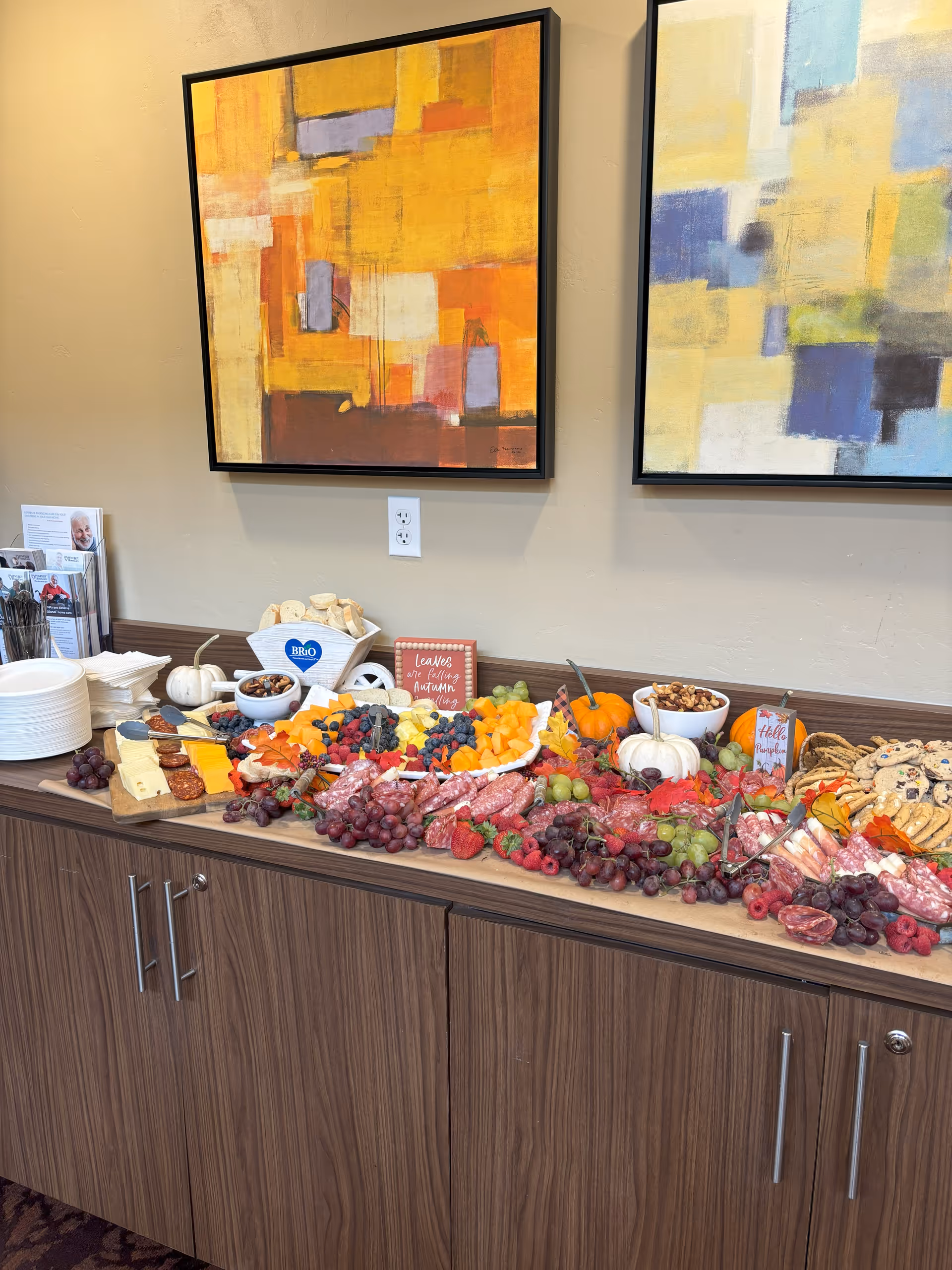 A long counter with cheese, fruit, and snacks arranged for a buffet in a dining area.