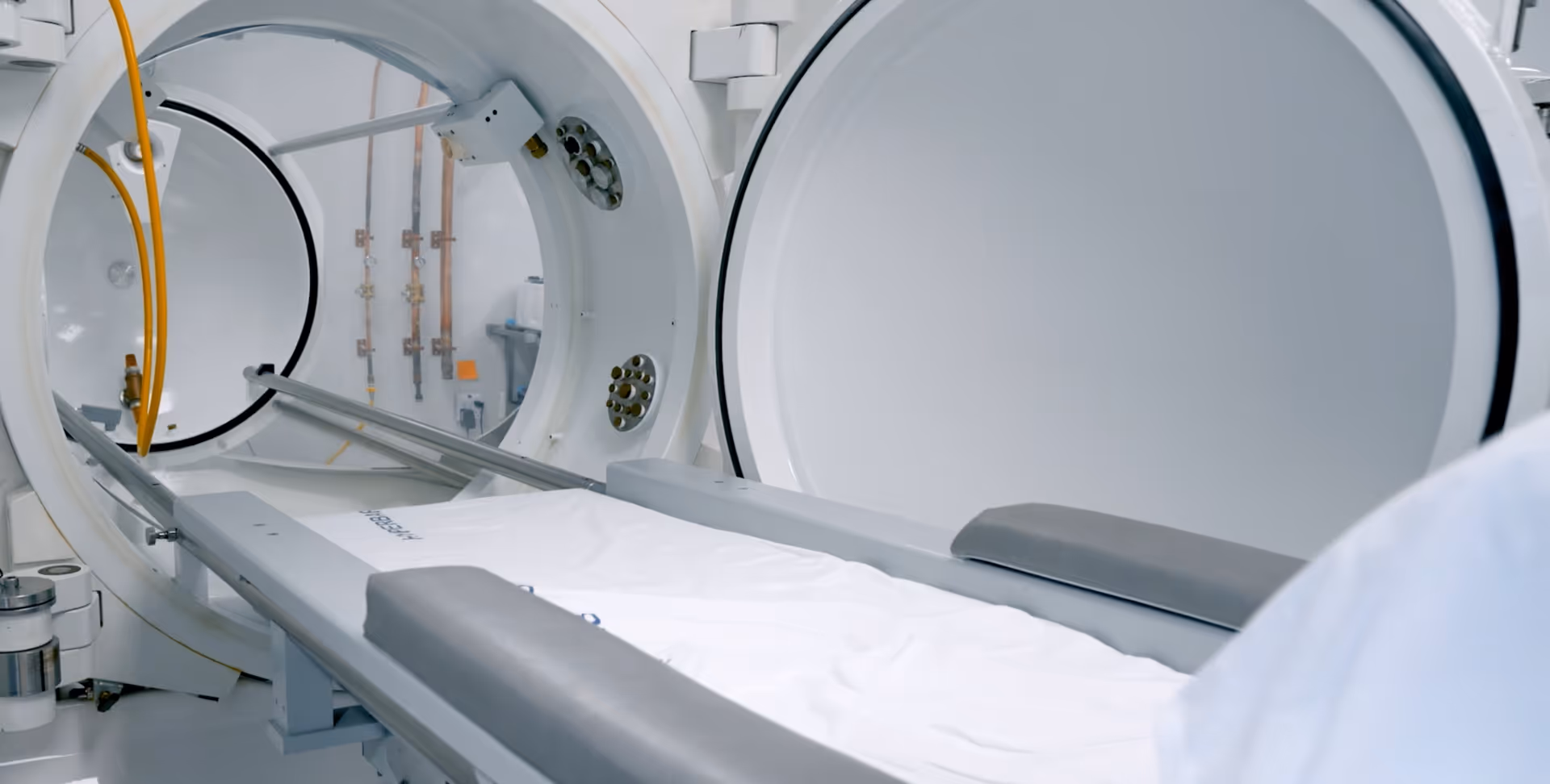 Medical imaging machine with patient bed inside a bright clinical scanner.