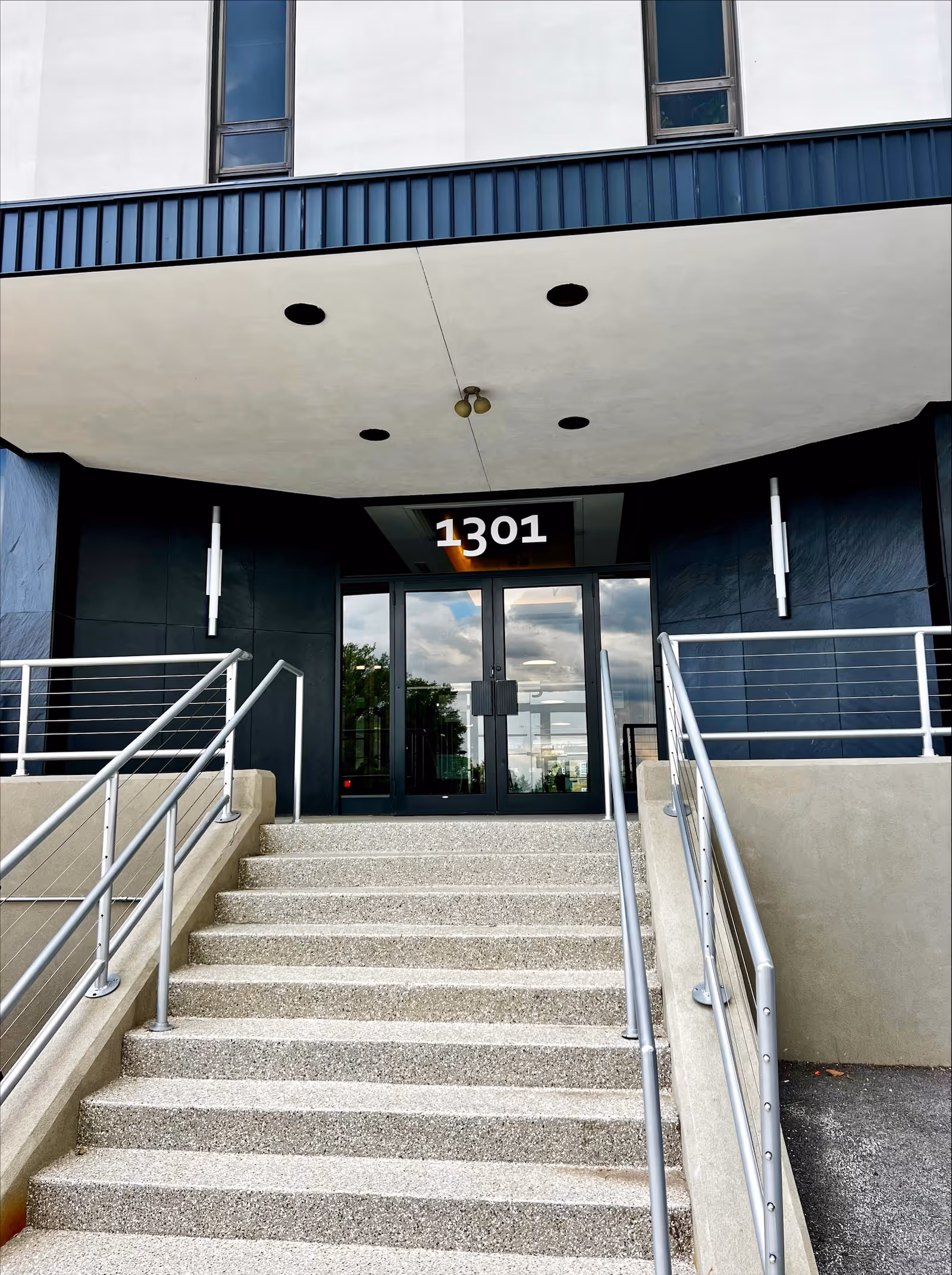 Front entrance of BAYADA Assistive Care building with stairs, glass doors, and address 1301.