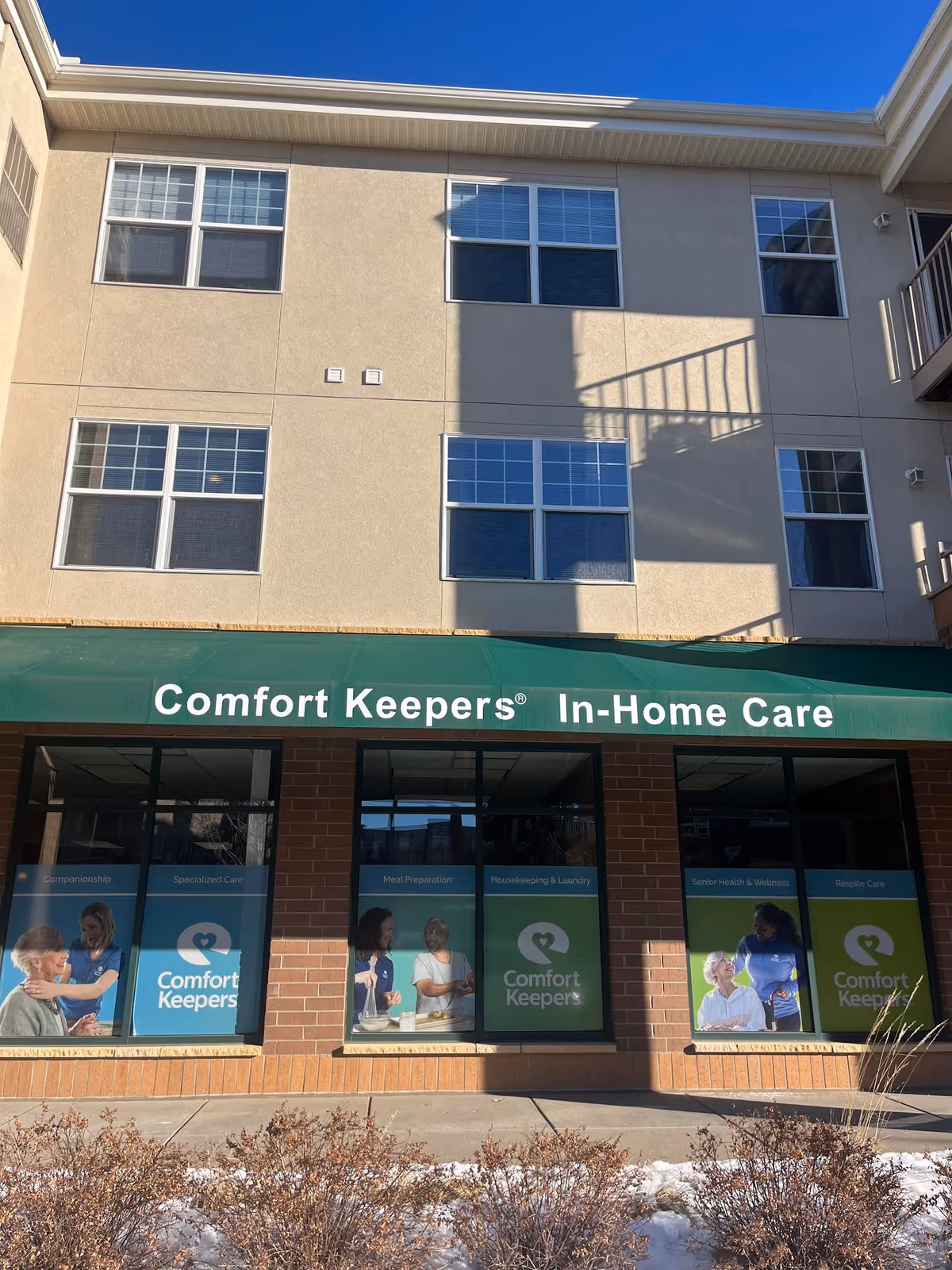 Exterior view of Comfort Keepers In-Home Care storefront on beige building.