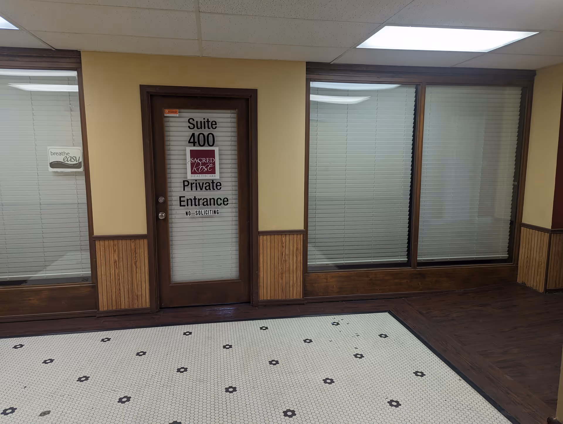Interior hallway with a private entrance door labeled Suite 400 and blinds on windows.