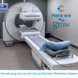 Siemens nuclear medicine camera in an imaging room with a patient bed and pillow.