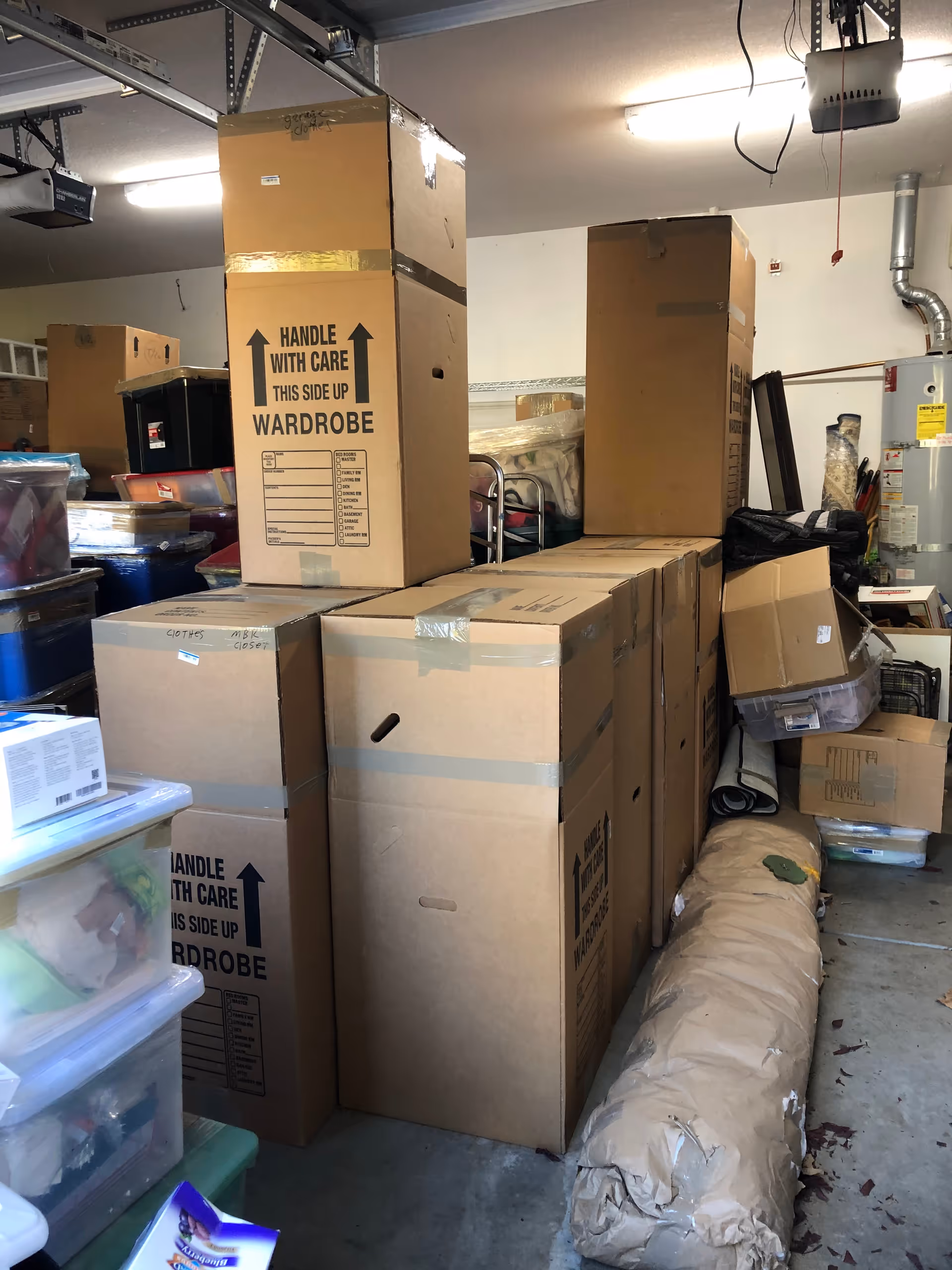 A cluttered storage room with stacked cardboard boxes and packing supplies.