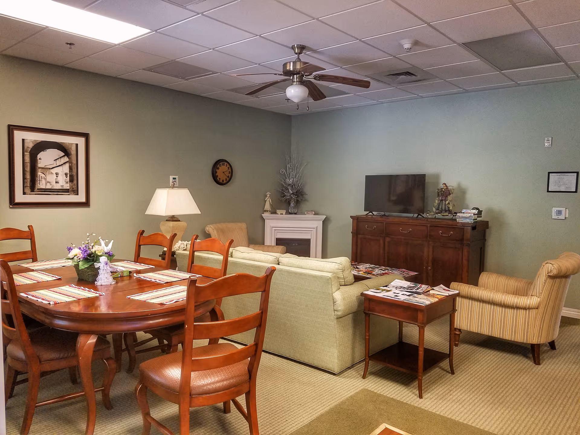 Cozy communal living area with round dining table, sofa, and TV.