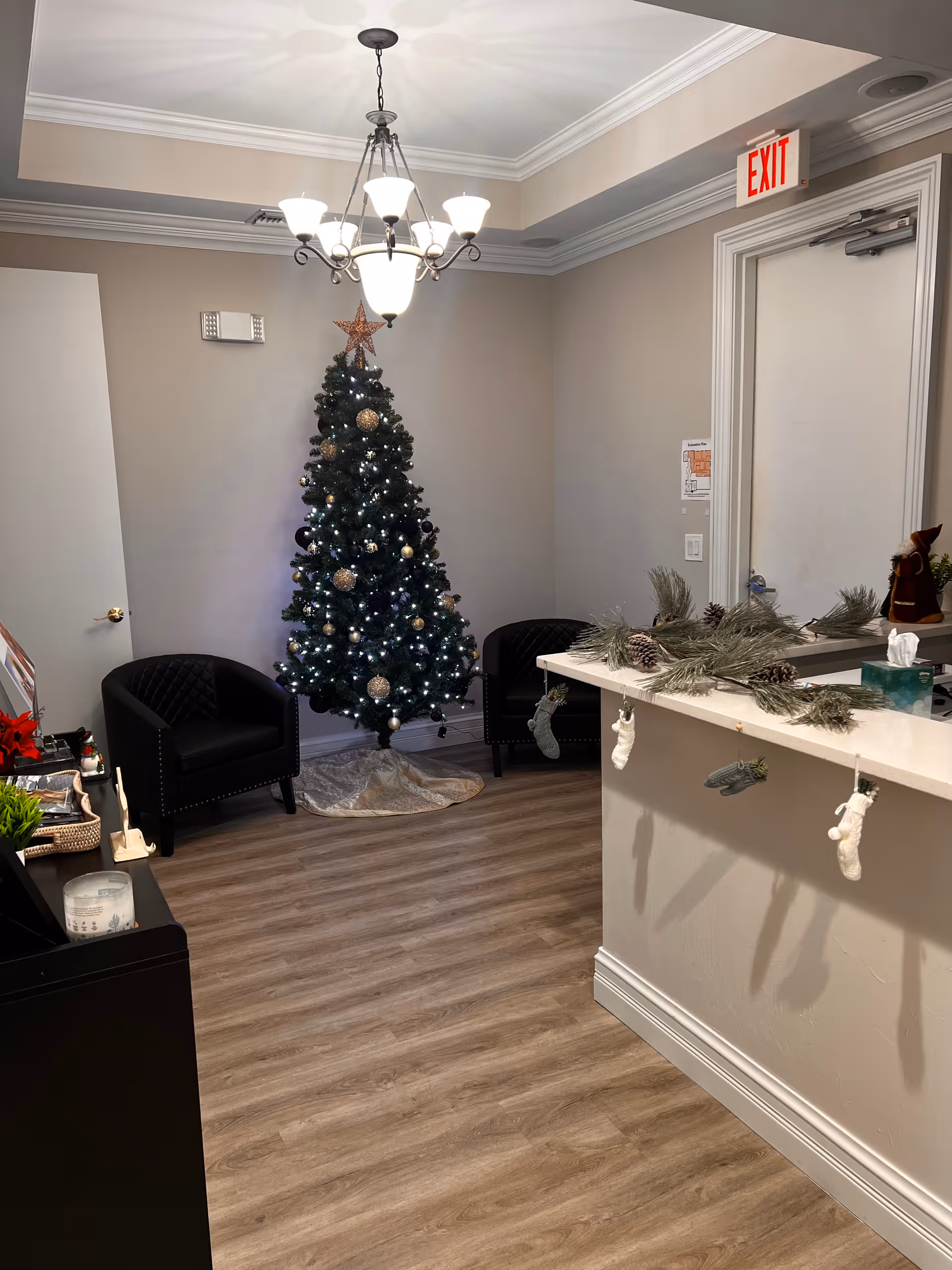 A cozy interior lobby with a Christmas tree, seating, and a decorated reception counter.