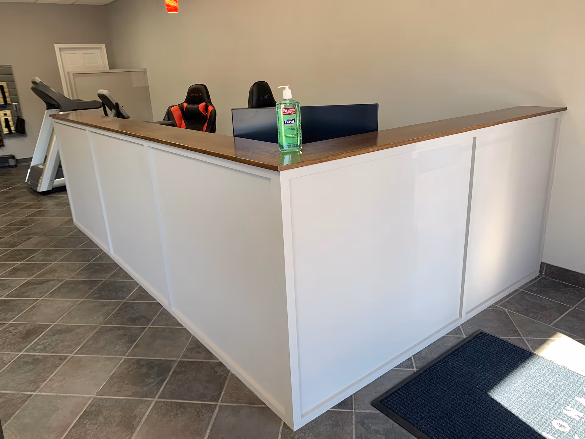 Reception desk in an interior lobby with a hand sanitizer bottle on the counter.