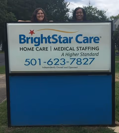 Outdoor BrightStar Care sign with two people peeking over the top.