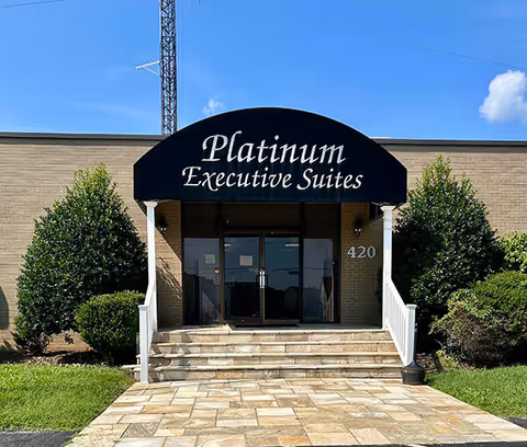 Exterior view of the building entrance with a black arched sign reading Platinum Executive Suites.