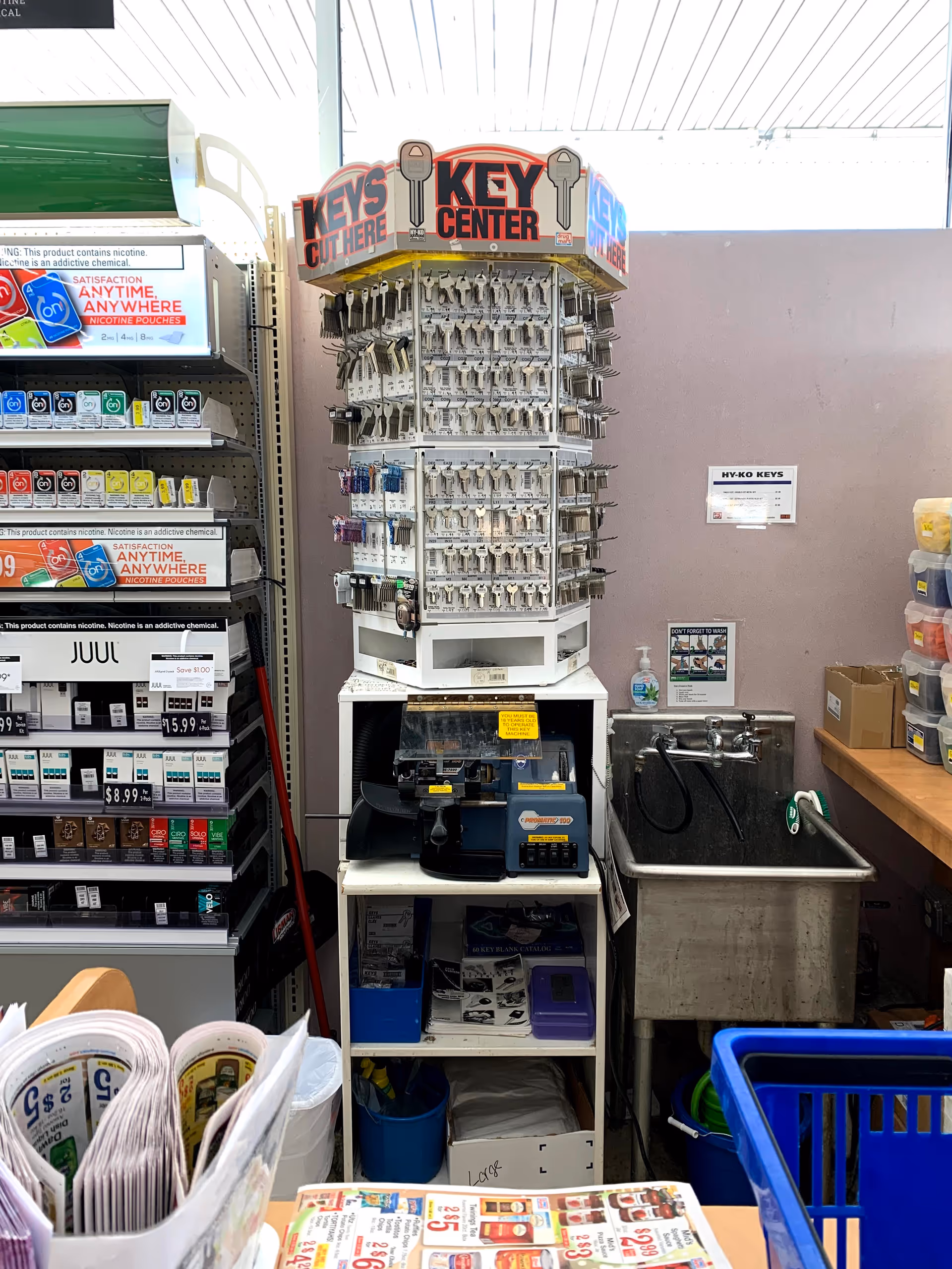 Tall key display rack with assorted products in Discount Drug Mart interior.