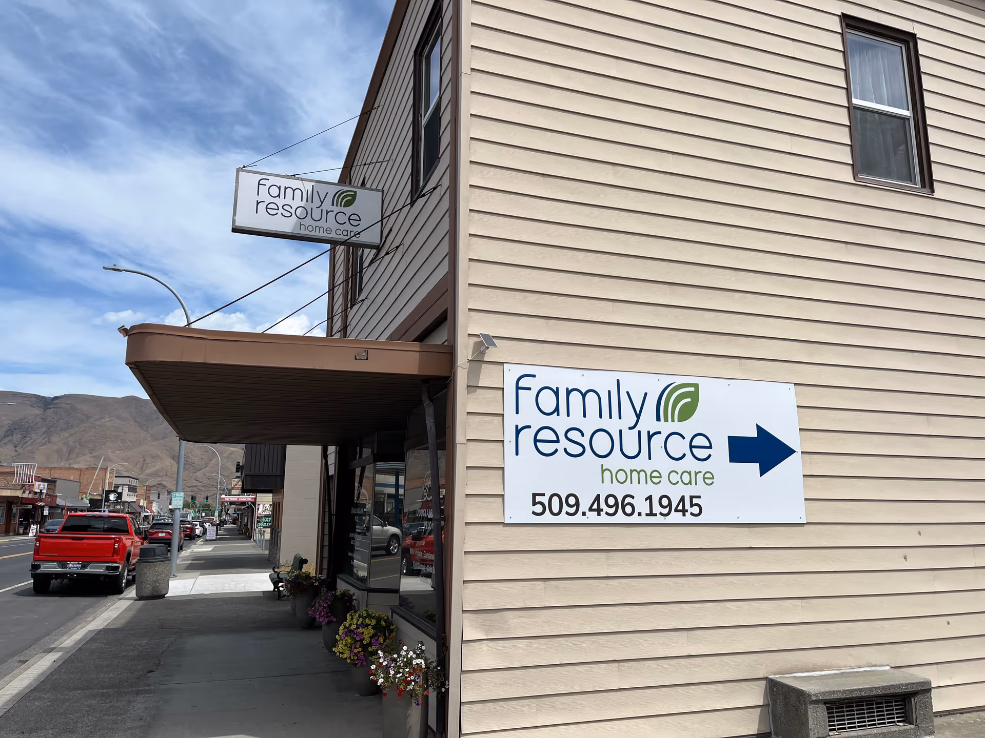 Street view of beige two-story building with Family Resource Home Care signage and blue arrow sign.