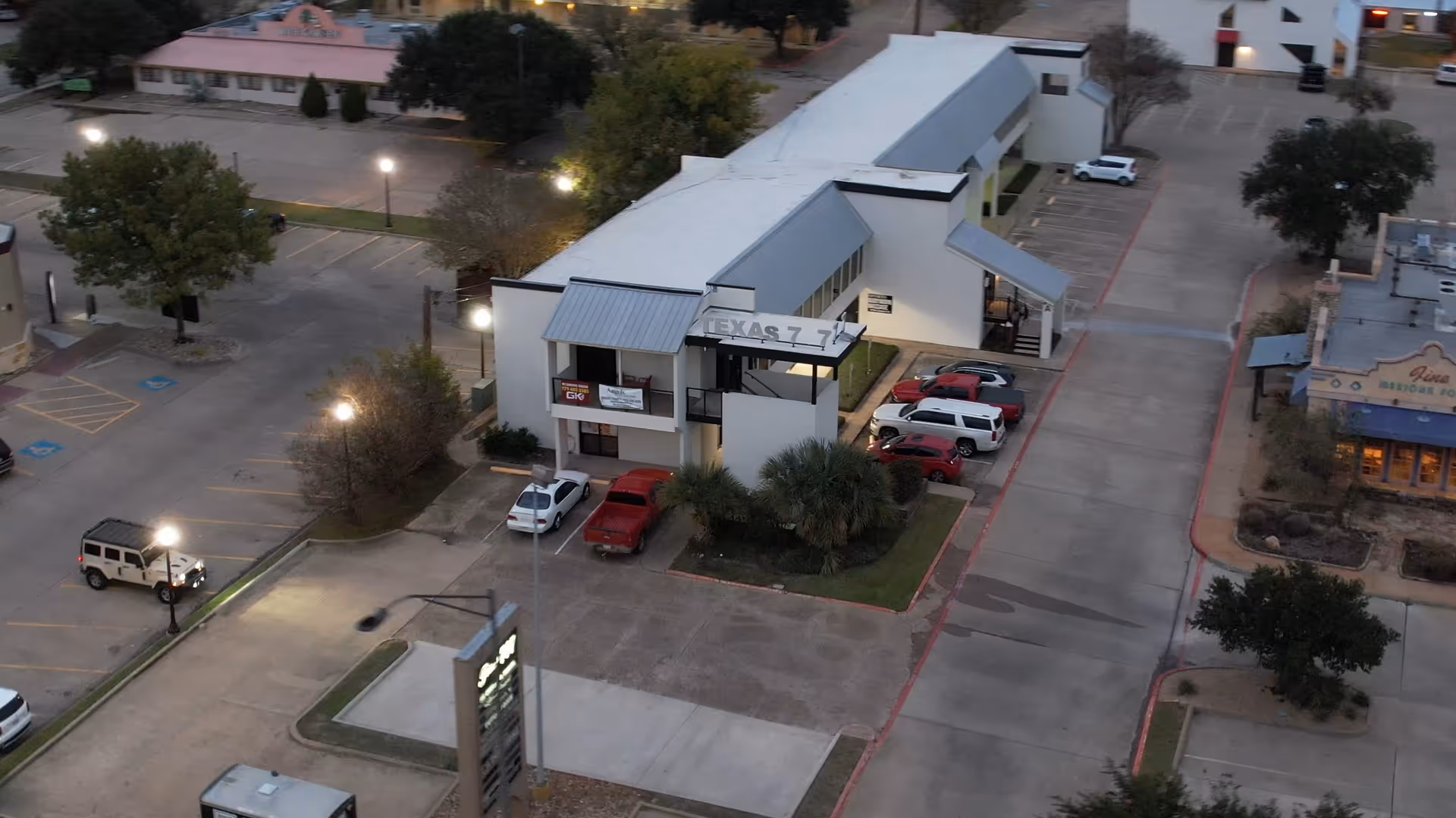Aerial view of a white senior care building complex with parking lots.