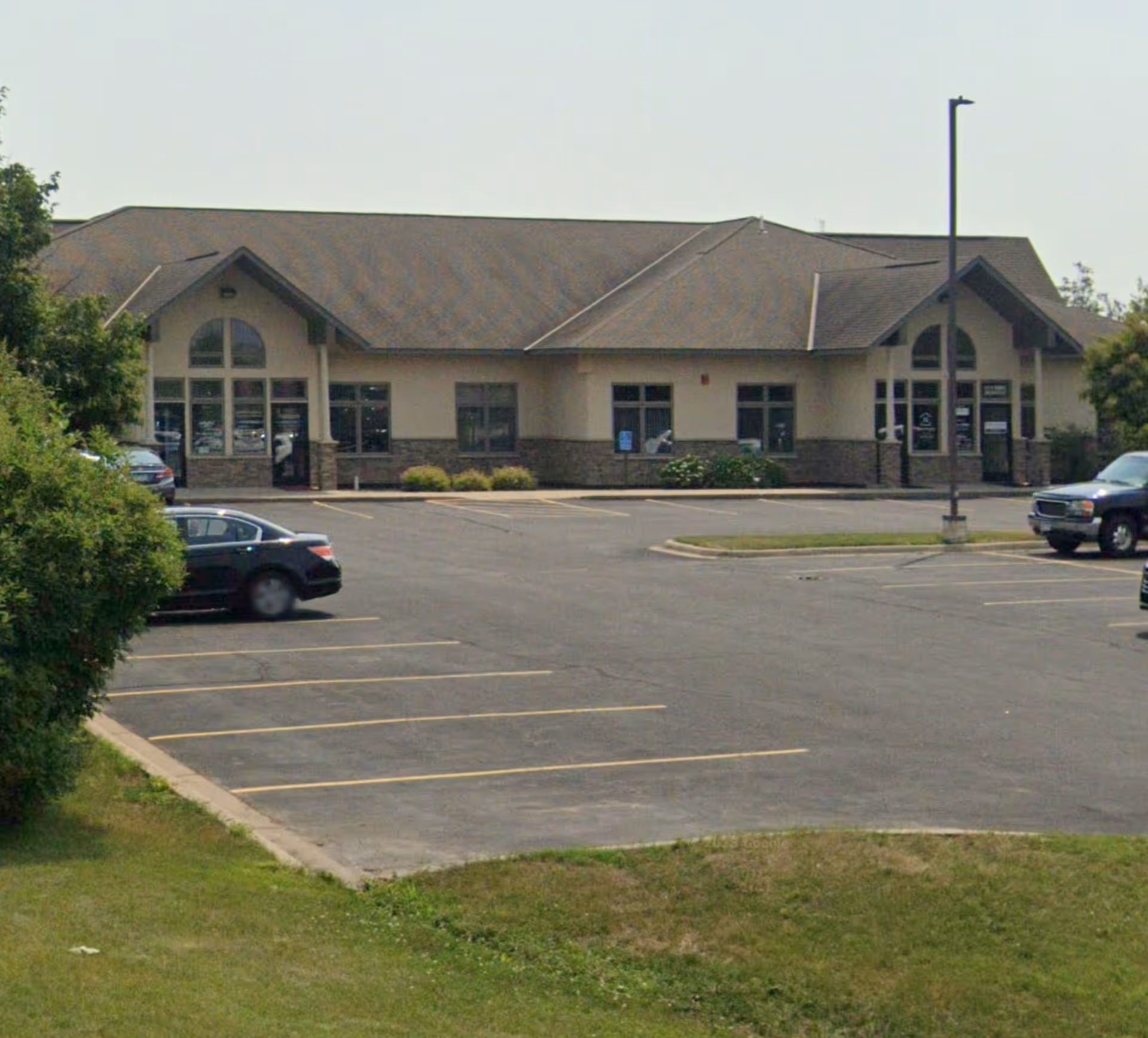 Exterior view of Home Instead senior living facility front with a parking lot.