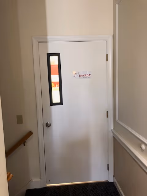 Interior hallway of a senior facility featuring a BAYADA Home Health door.