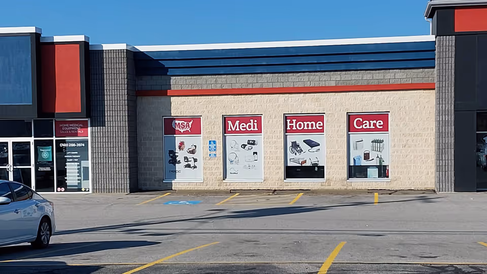 Exterior view of Medi Home Care storefront with signs and a parking lot.