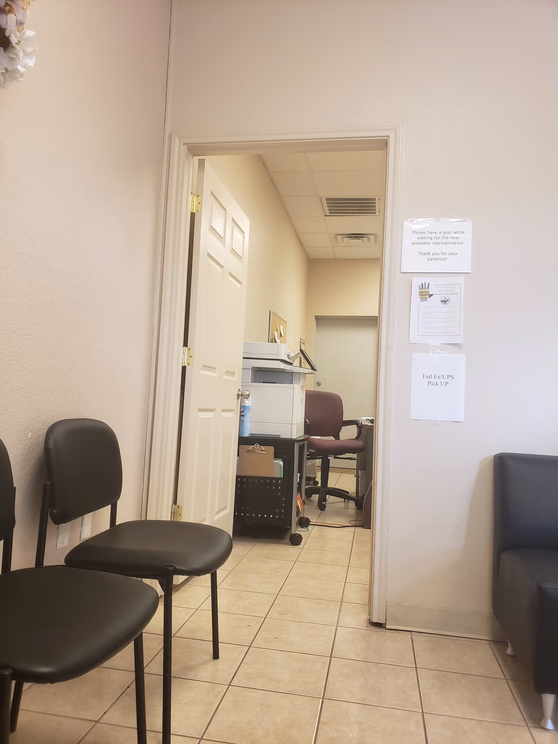 Interior waiting area of American Home Patient facility, with chairs, a printer, and doorway.