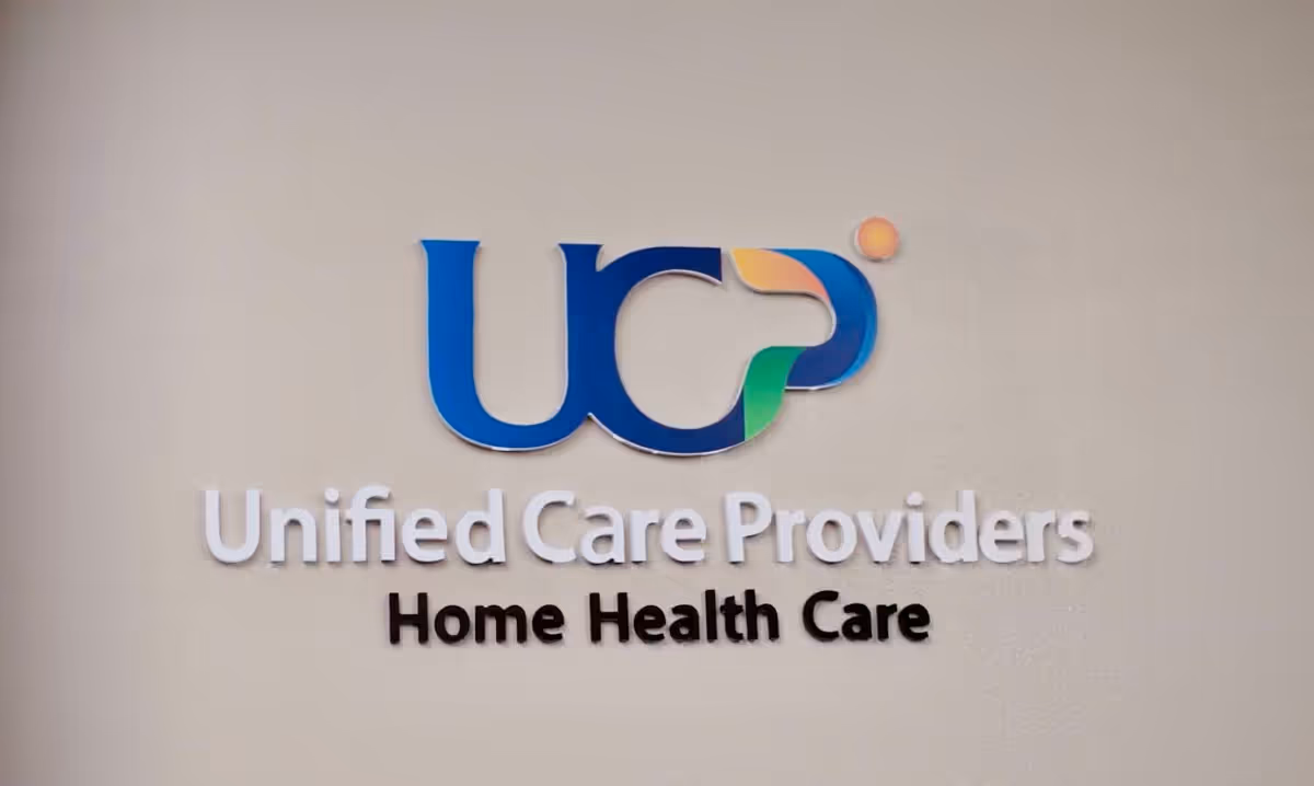 Interior wall sign reading Unified Care Providers Home Health Care with colorful logo
