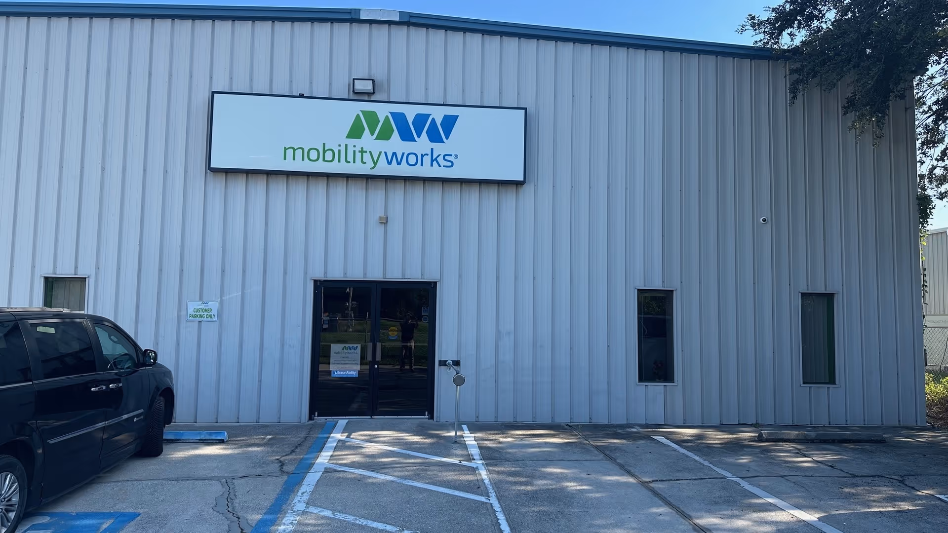 Exterior view of MobilityWorks building with sign and parking in front