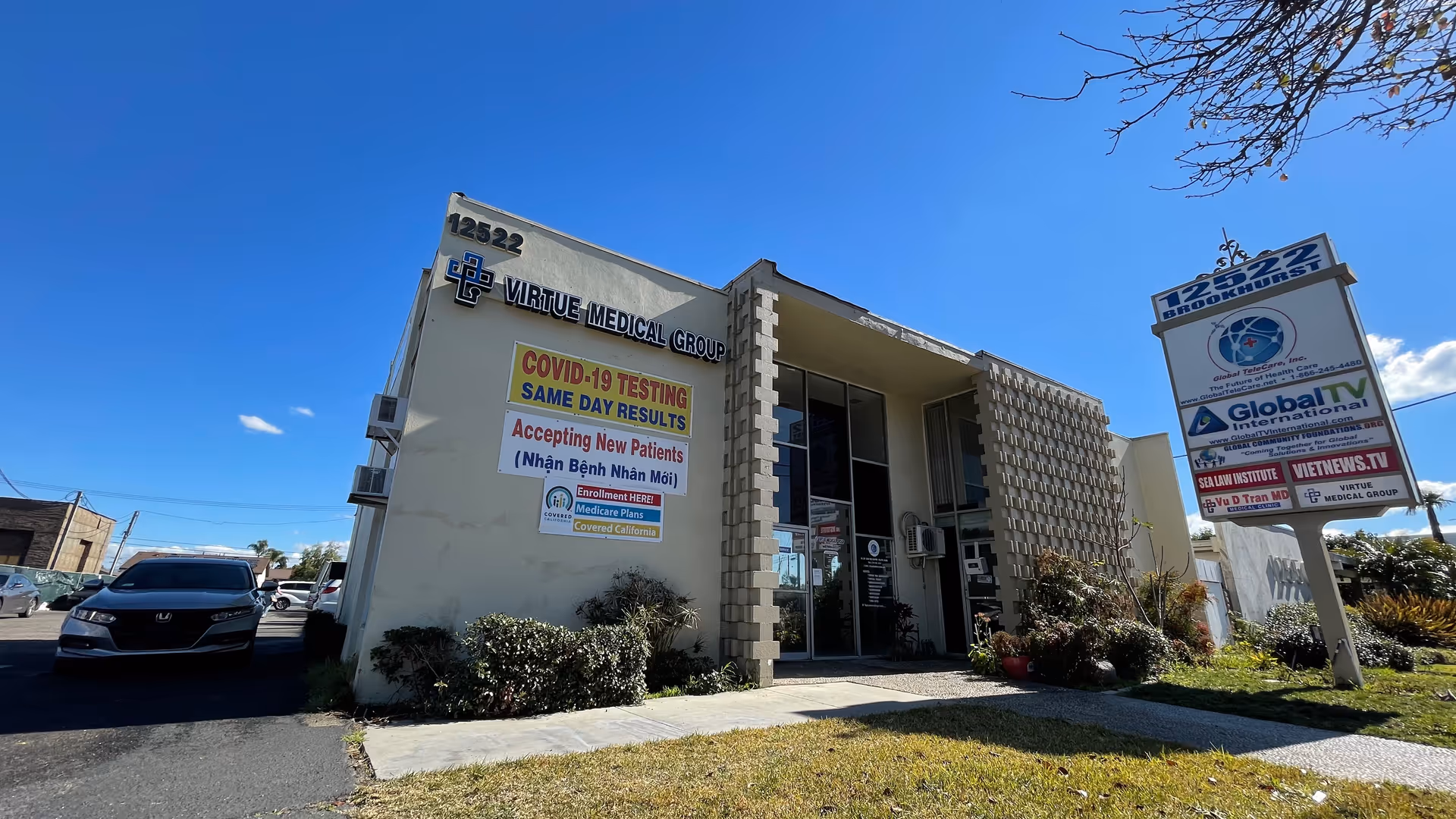 Exterior view of Virtue Medical Group building with entrance, signage, and parked cars nearby.