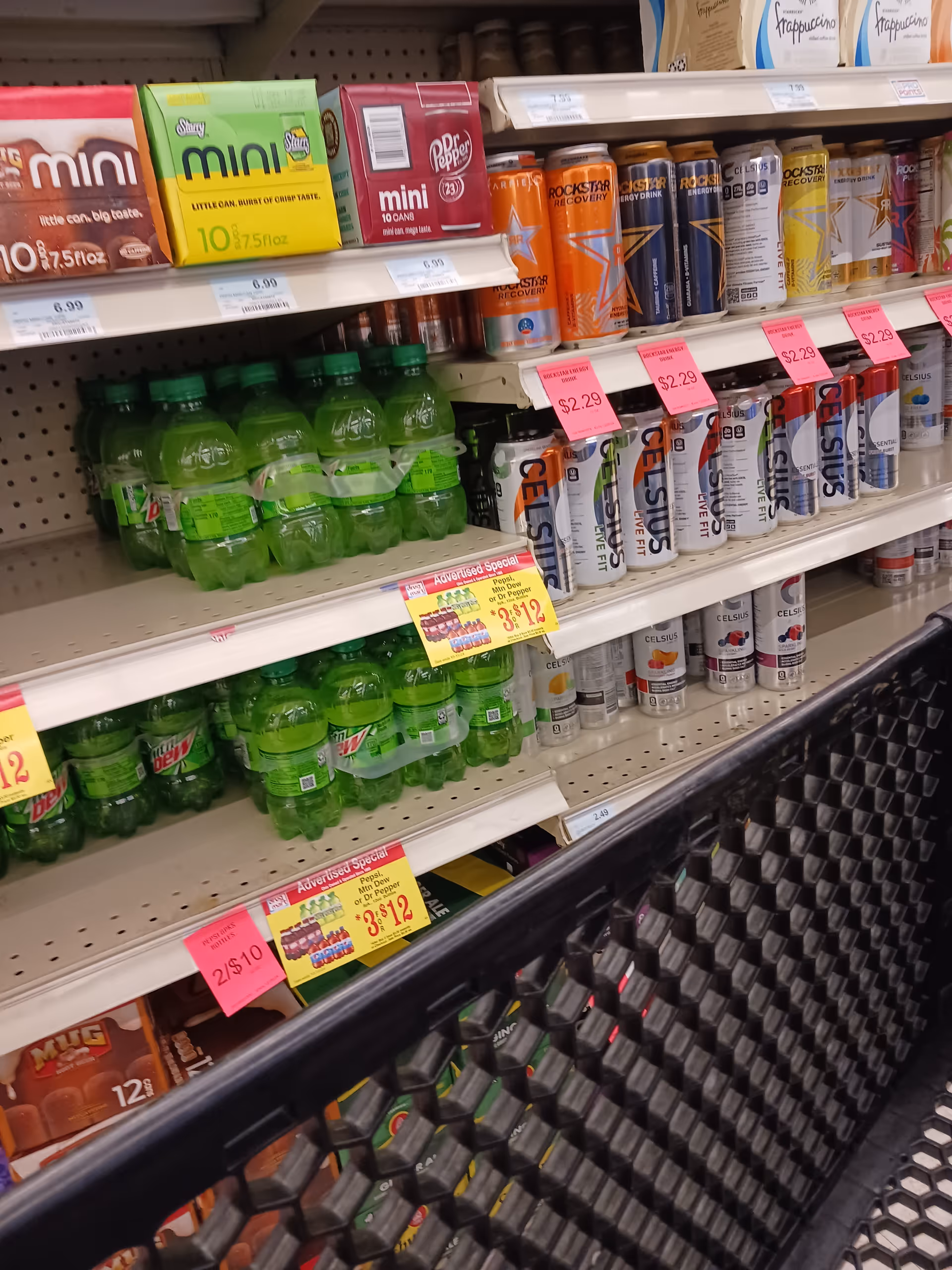 Aisle of bottled beverages and energy drinks on store shelves inside Discount Drug Mart.
