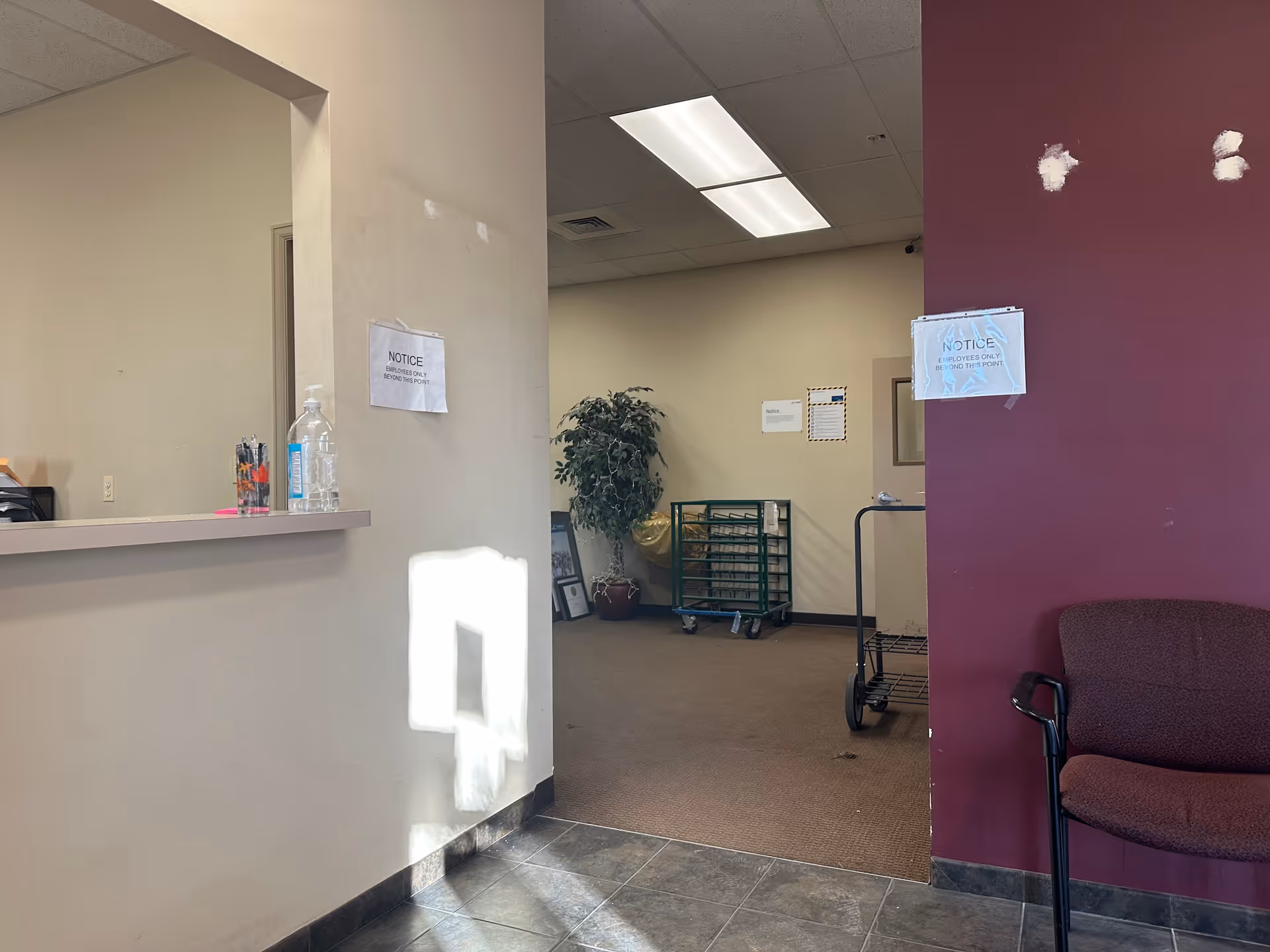 LINCARE facility interior lobby with reception desk, maroon wall, seating, and a cart.