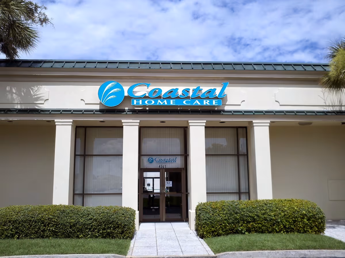 Front view of a single-story senior care building with Coastal Home Care sign and landscaping.