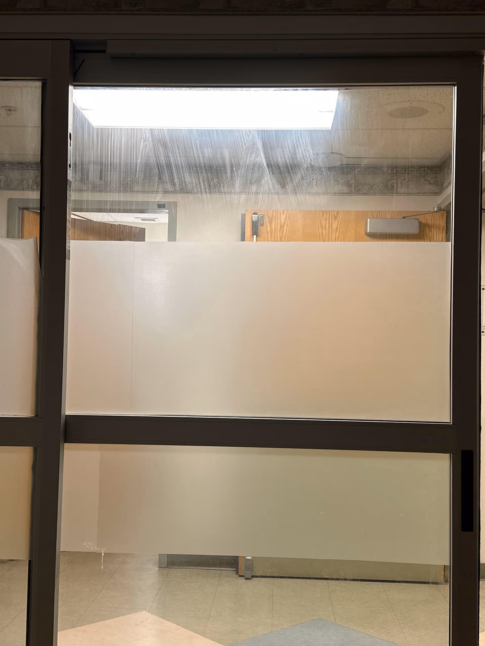 Interior hallway with frosted glass partitions and door frames.