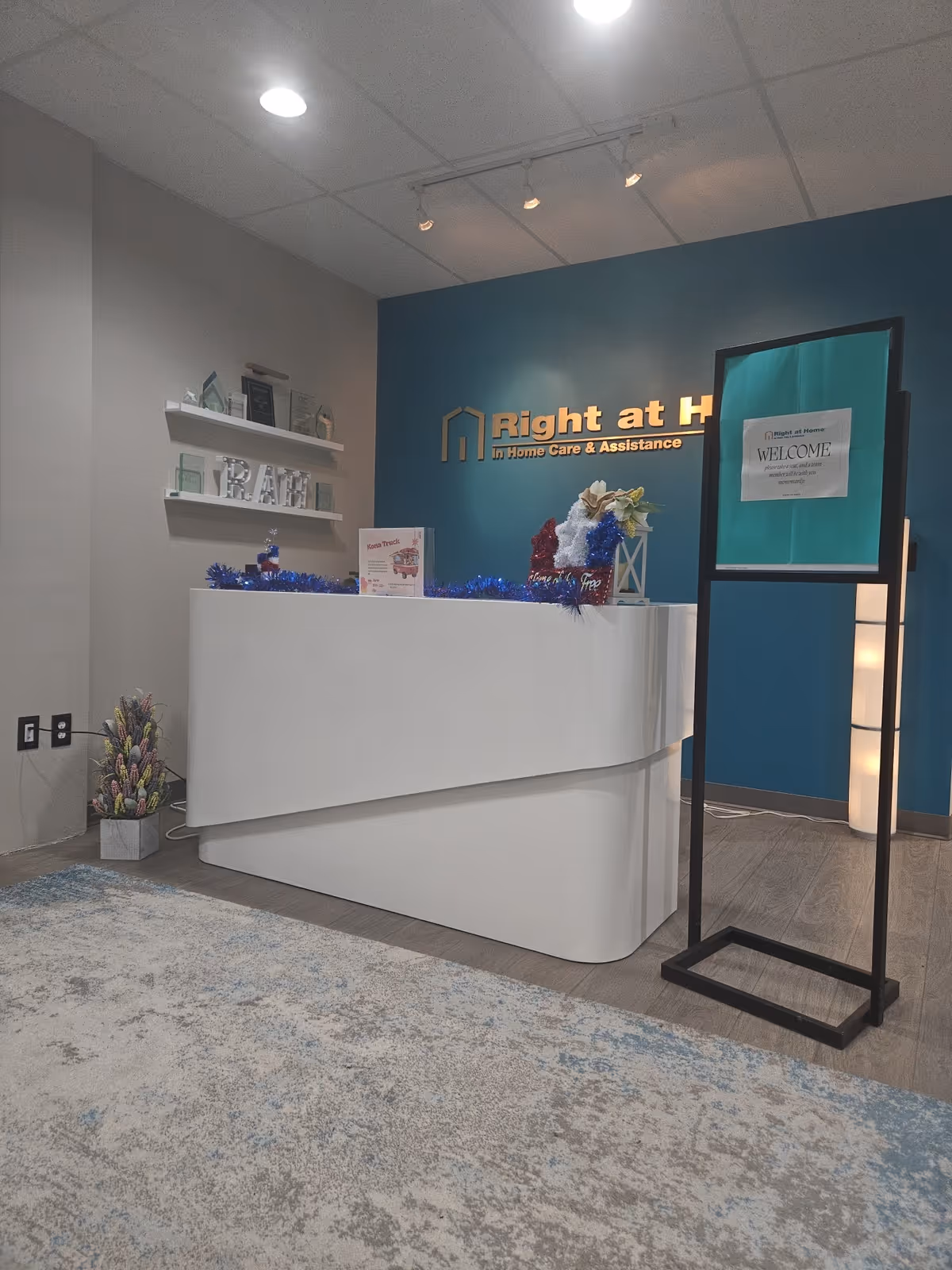Reception desk in a senior living facility lobby featuring Right at Home branding on a wall.