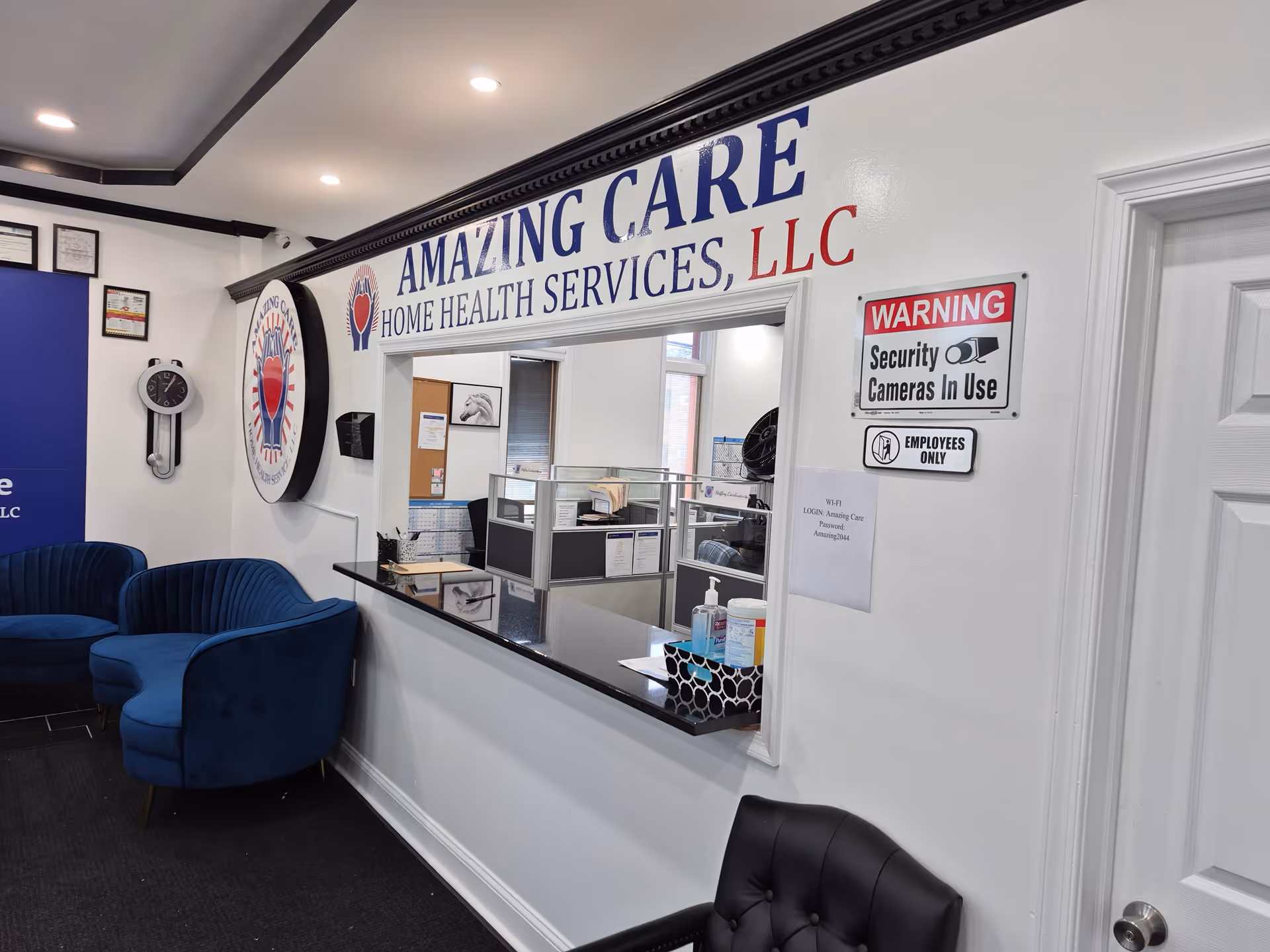 Reception area of Amazing Care Home Health Services with blue chairs and a service window.