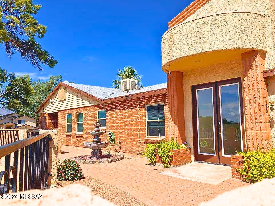Brick exterior of a senior living facility with a courtyard fountain and double doors.